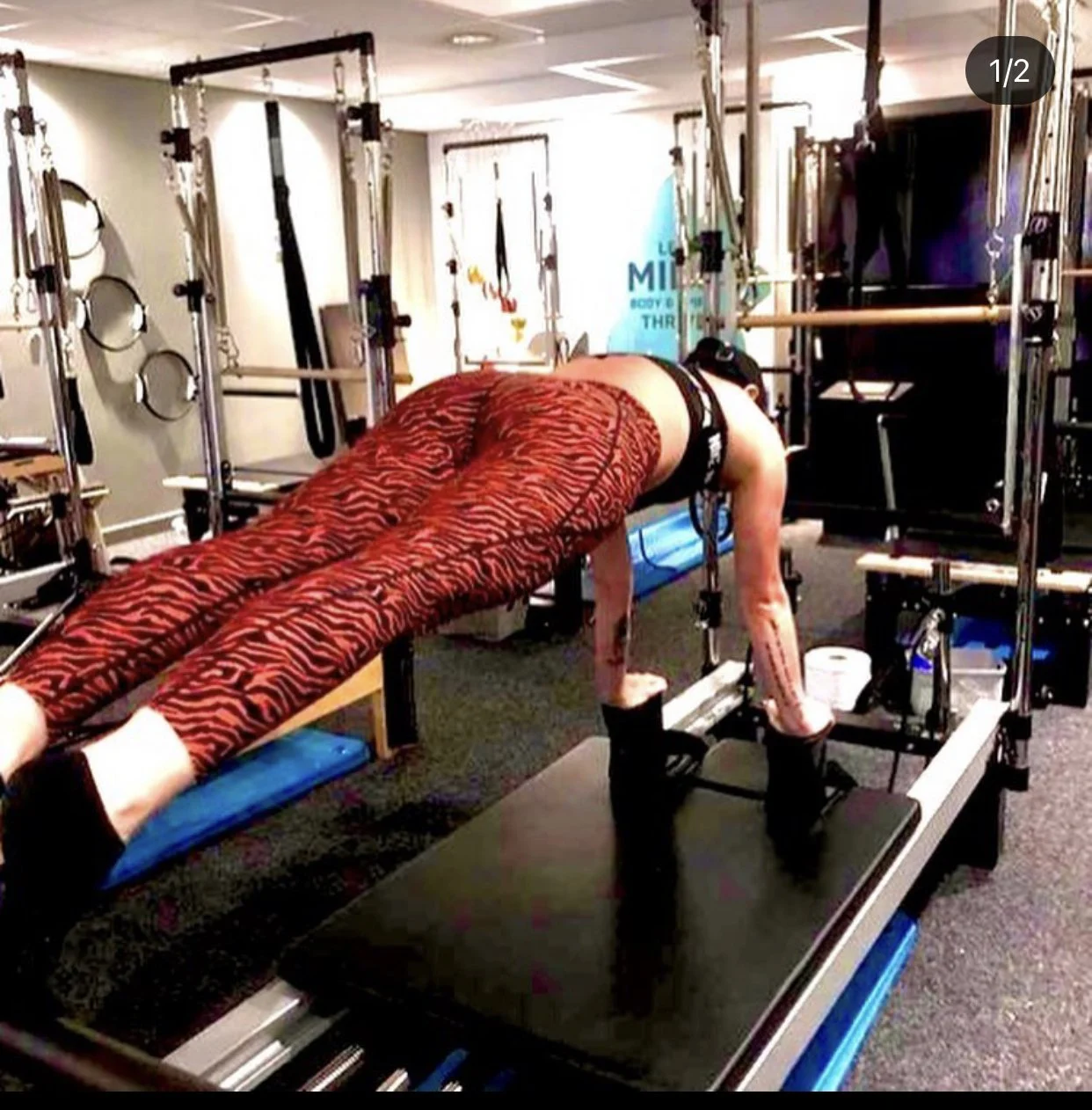 Person doing a Pilates exercise on a reformer machine in a studio.