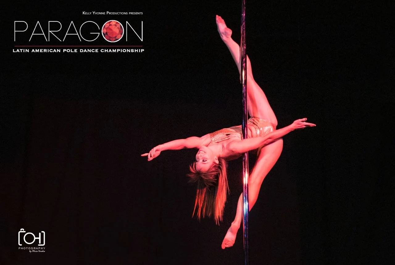A female pole dancer performing an acrobatic move on a vertical pole, with a dark background, promoting the Paragon Latin American Pole Dance Championship event.