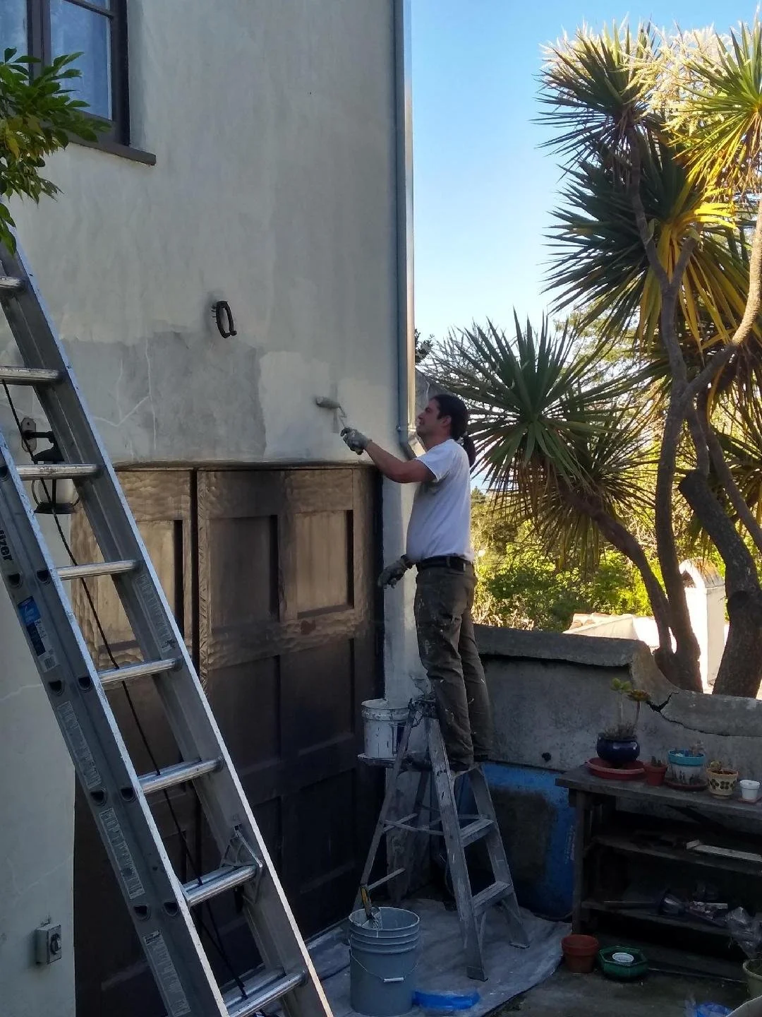 Exterior painting of a historic home with detailed trim restoration in Berkeley, CA. Progress shot.