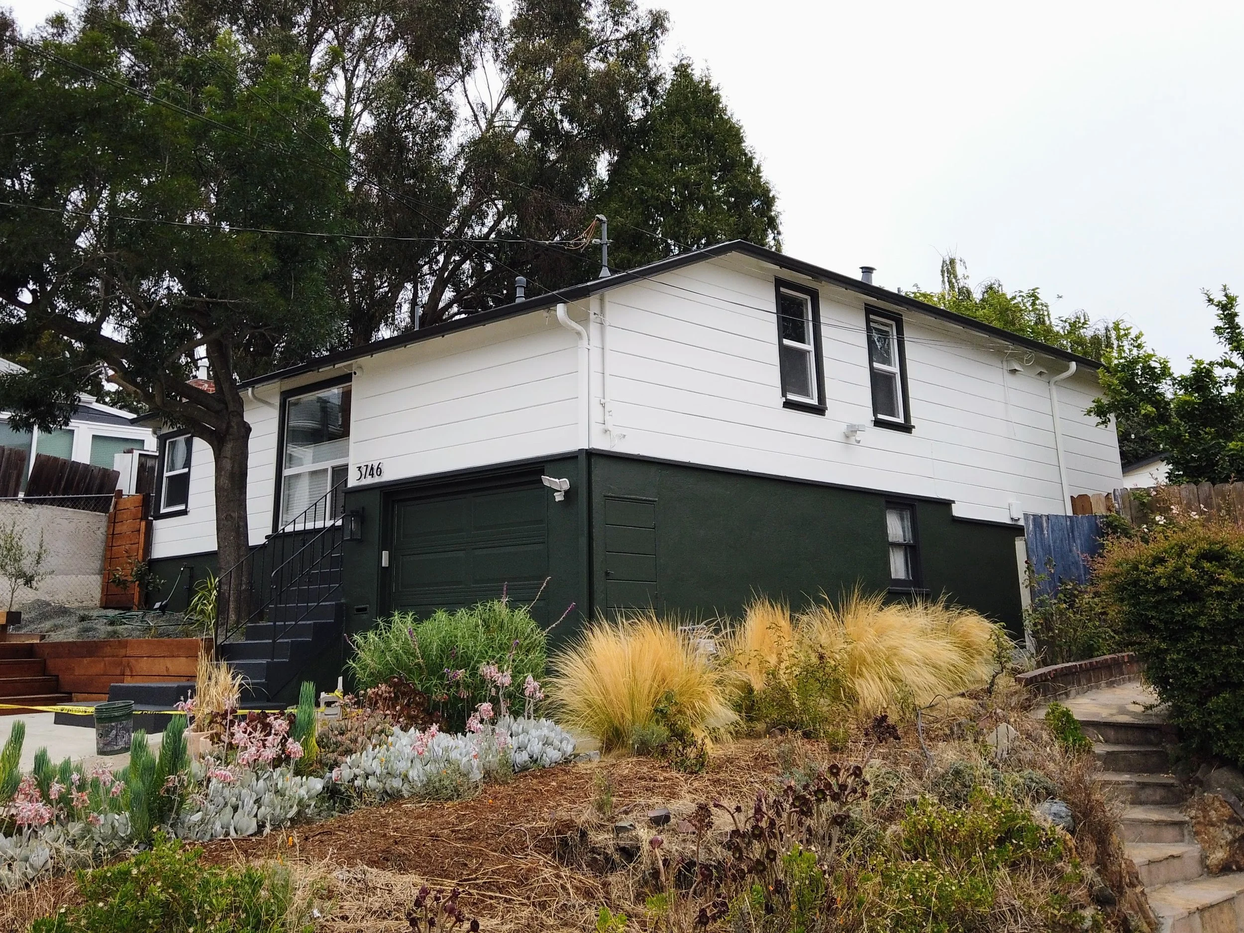Exterior home transformation with new paint on siding, trim, and doors in Oakland, CA.