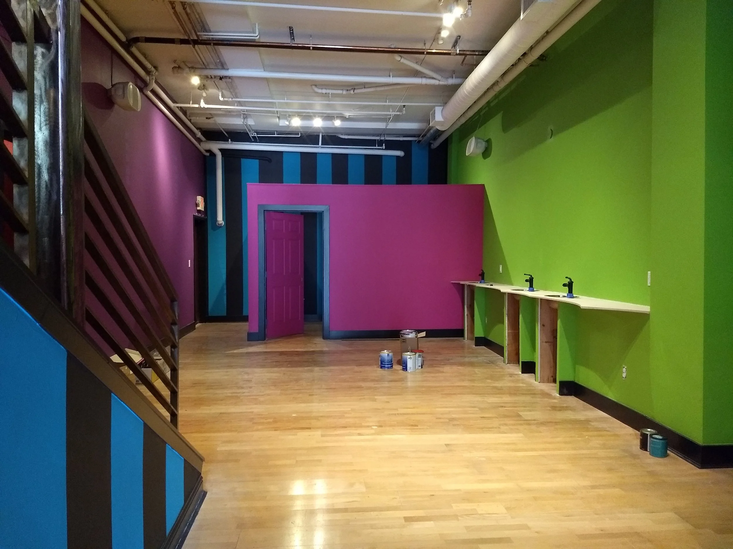 interior photo of tattoo parlor painted with bright colors and vertical stripes 