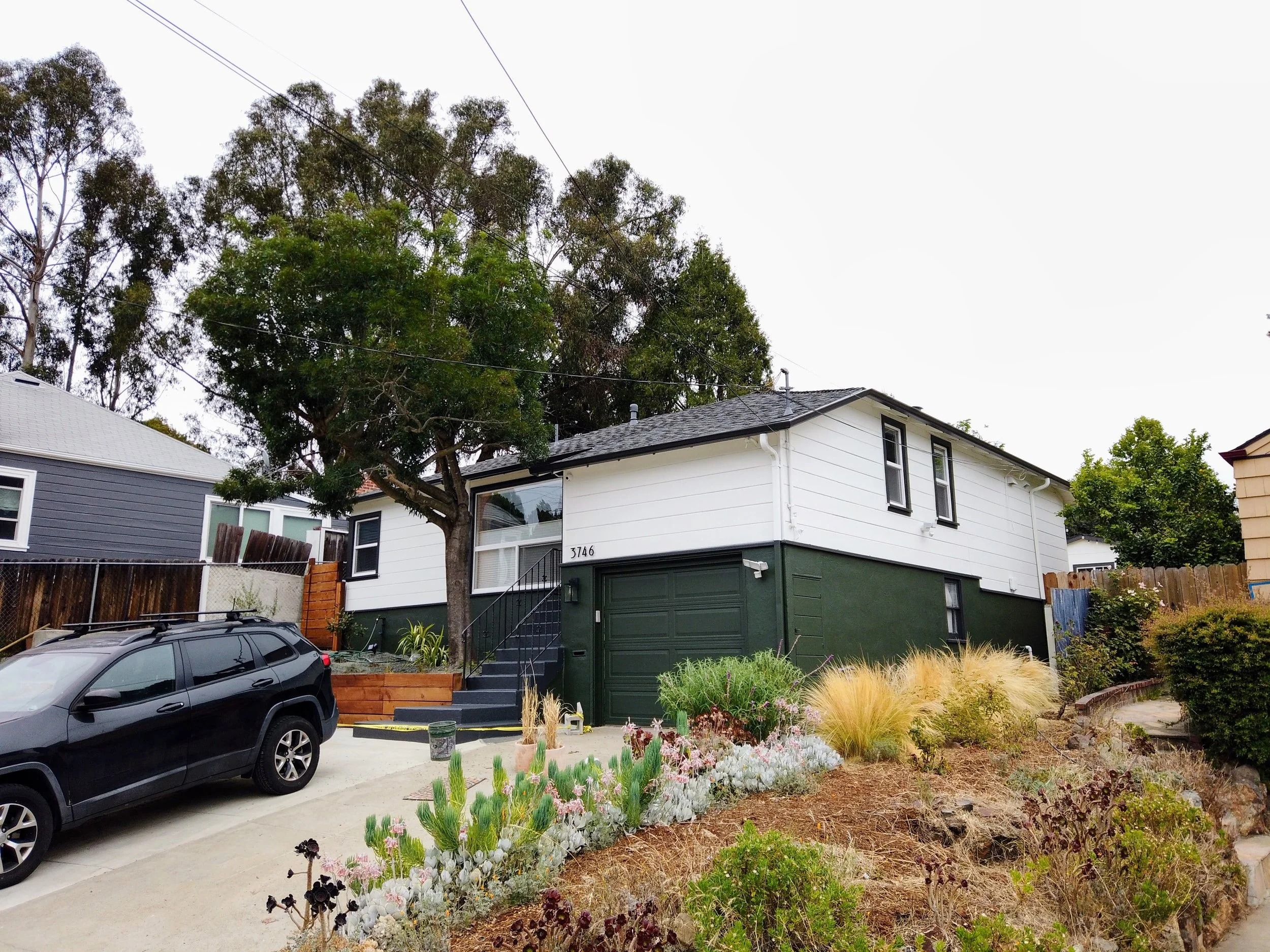 Exterior home transformation with new paint on siding, trim, and doors in Oakland, CA.