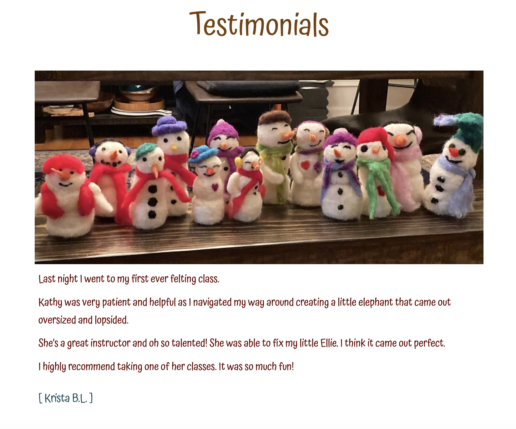 A display of multiple handmade felt snowmen in various sizes and colorful accessories, arranged on a wooden table.