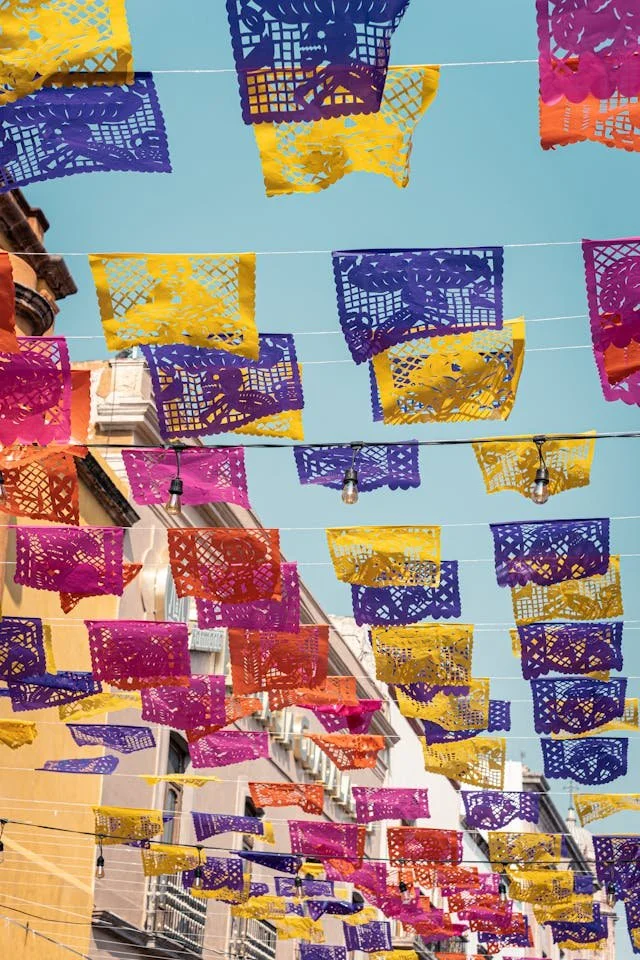 Vibrant papel picado decorations against a blue sky