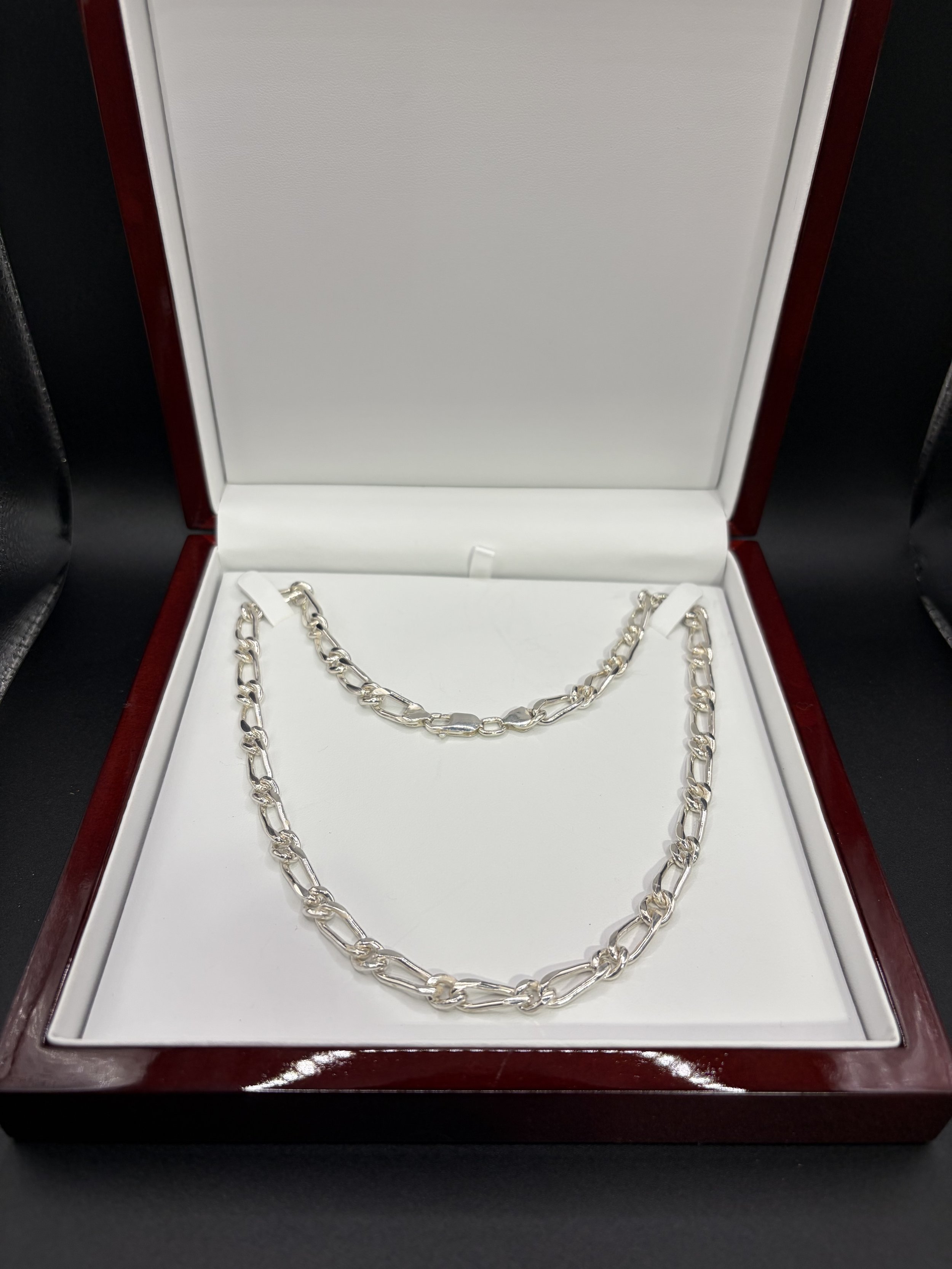 Silver Great Dane chain necklaces in a red wood jewelry box with white interior.