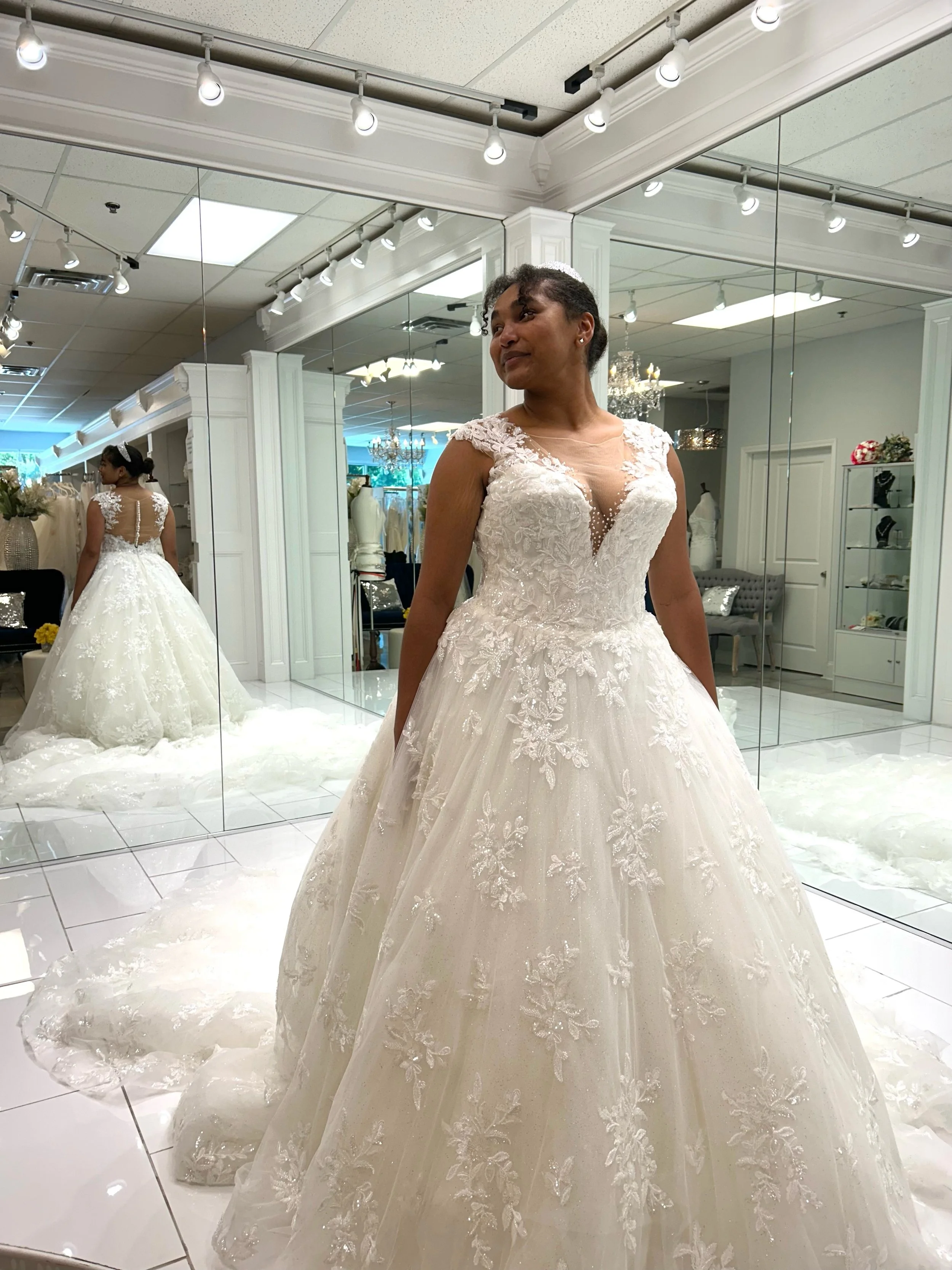 With shimmering beaded lace, sparkling tulle, elegant cap sleeves, and a button up illusion back, this ball gown is giving fairytale wedding from every angle ☺️✨ The only thing missing is the perfect bride to this beauty home 🥹 Book your appointment