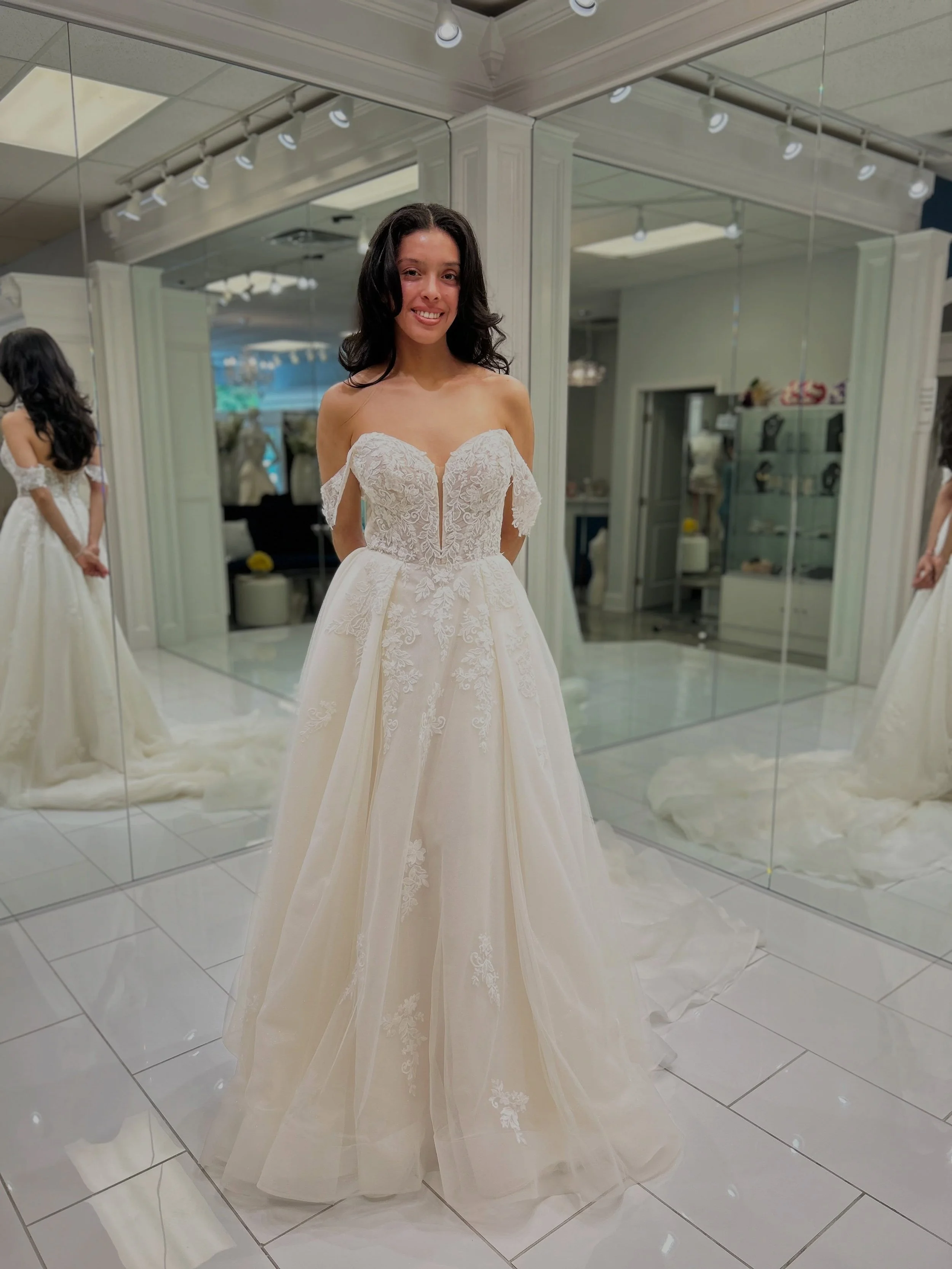 This modern ball gown is giving us EVERYTHING! Corset bodice with delicate draping, lace appliqu&eacute;&rsquo;s cascading over sparkle tulle, dream box pleated skirt, and pearl infinity buttons going down the train 😍✨ Could this be your dream dress