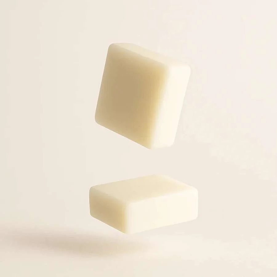Filtres de savon en forme de motifs floraux de couleur blanche et orange, avec des fleurs blanches en arrière-plan.
