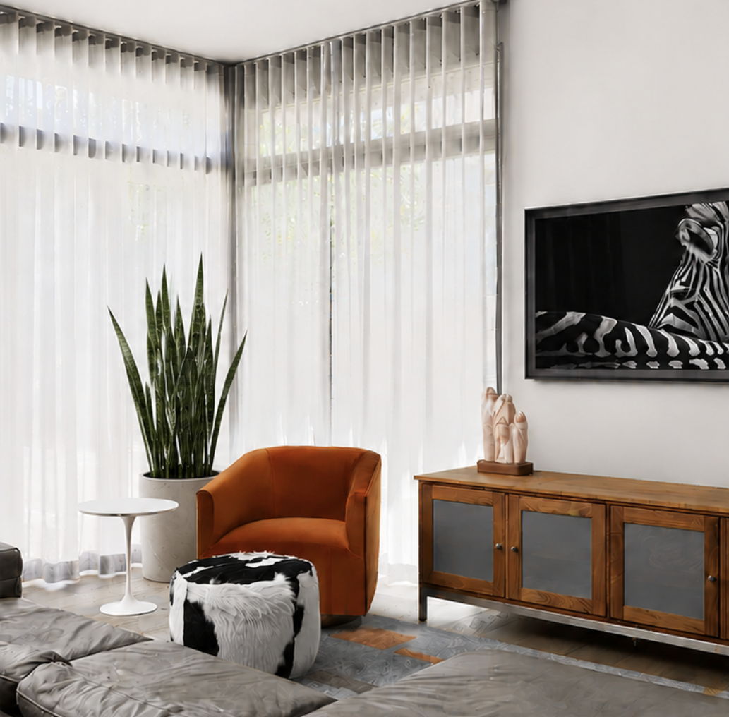 Modern living room with sheer white curtains, a gray sofa, an orange armchair, a black-and-white cowhide ottoman, and a wooden sideboard decorated with a small potted plant, a pink sculpture, and candles. A large wall-mounted TV displays a black and white image of a zebra.
