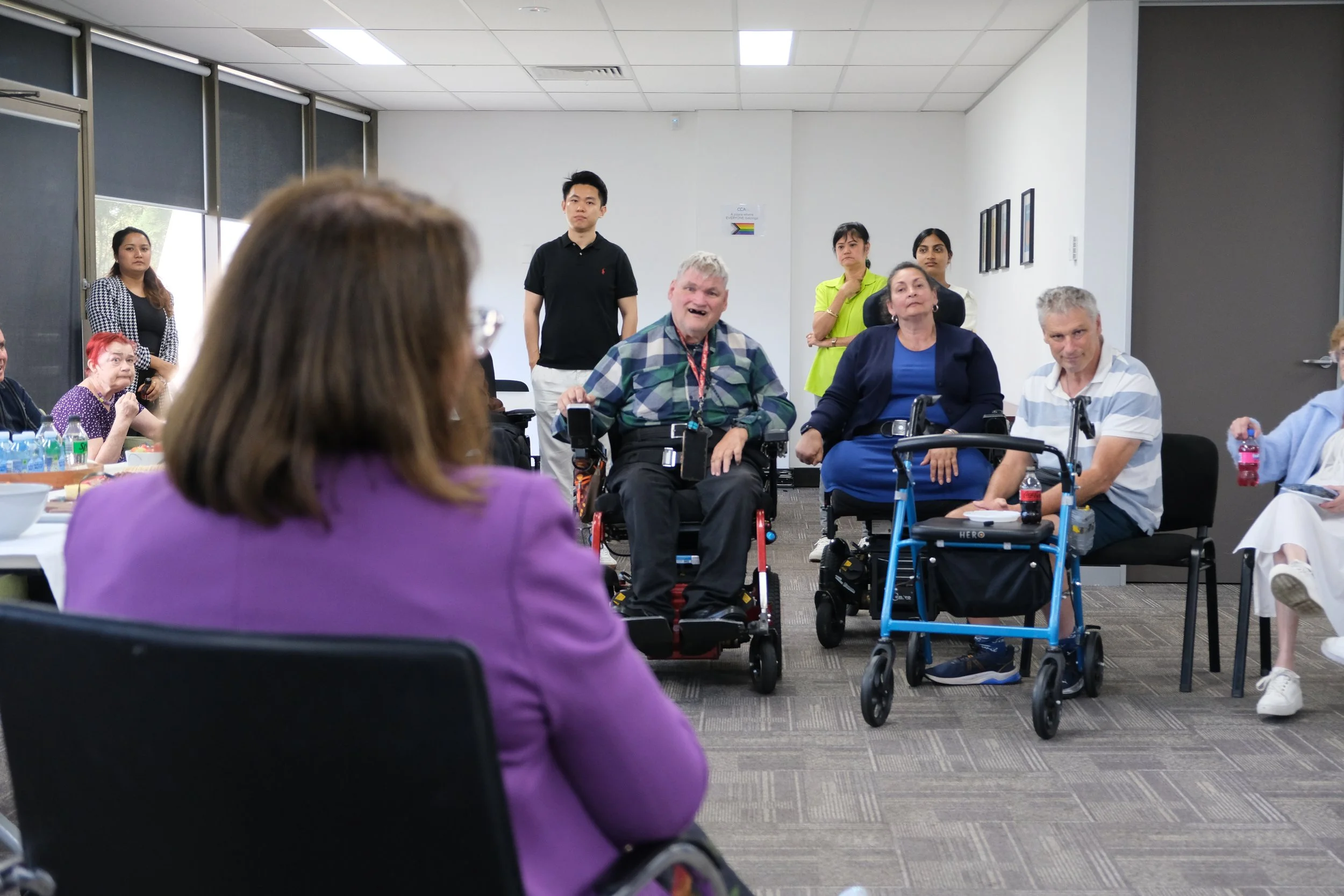 A group of people living with disability in an office listening to a talk about politics