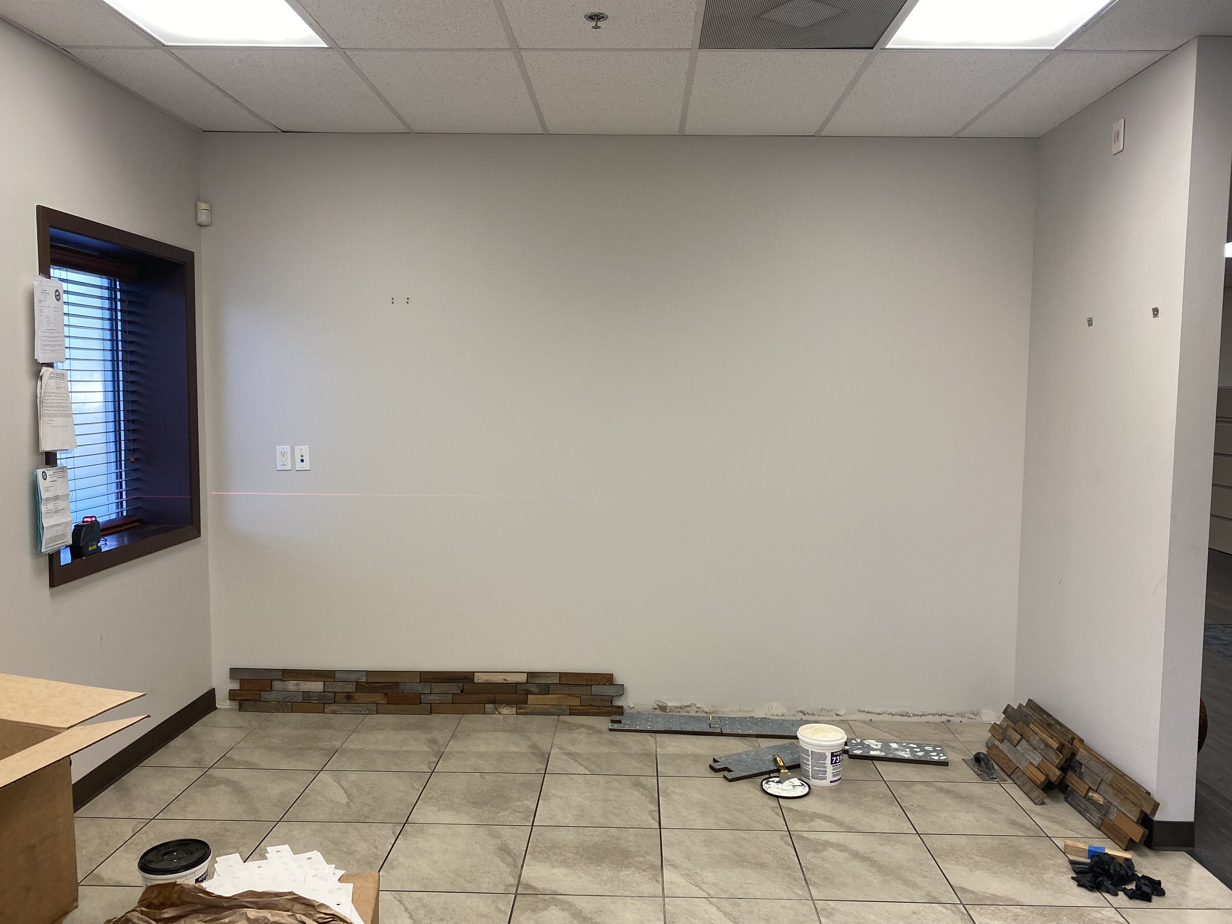 Interior room under renovation with tiled floor, tools, and wall materials.