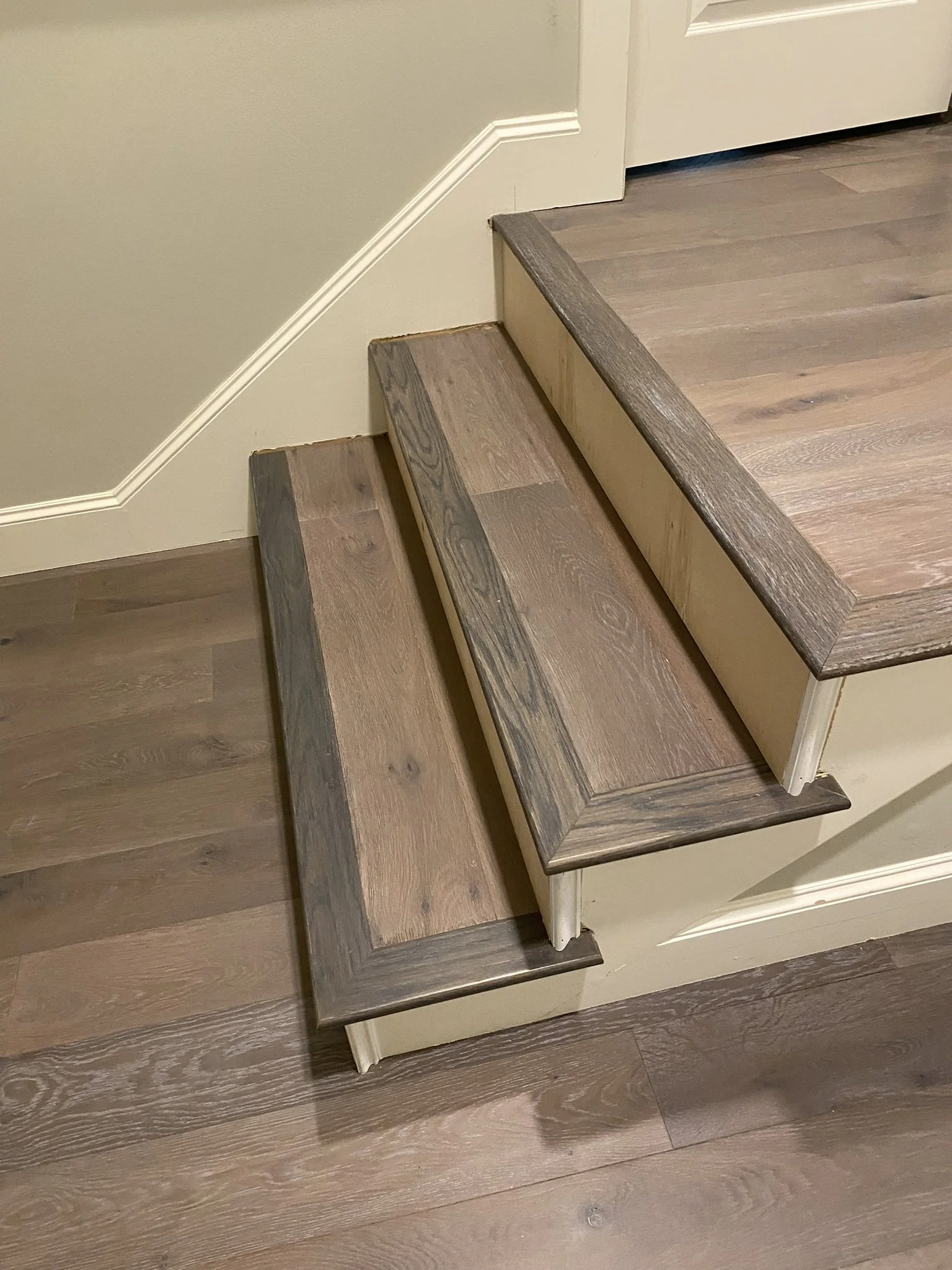 Two wooden steps with a beige wall on the side