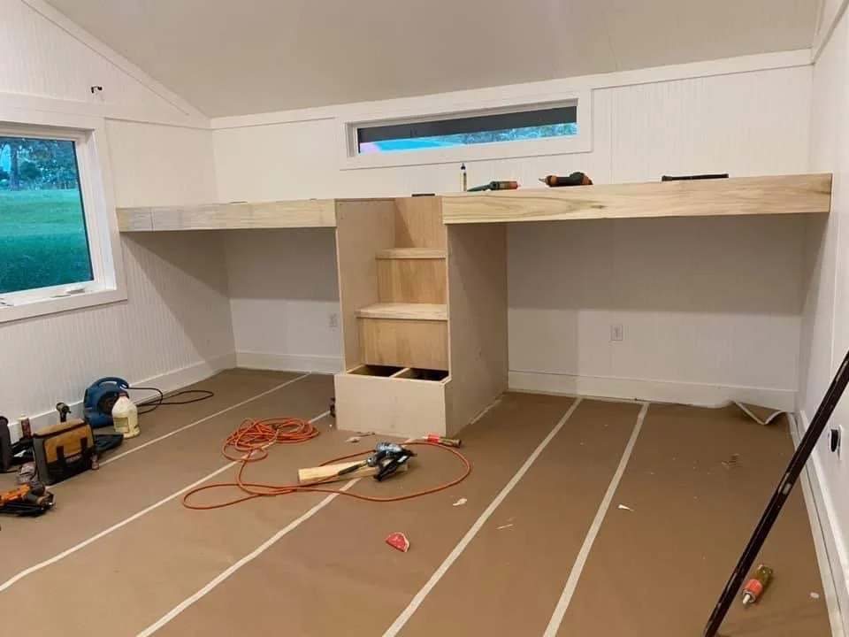 Room under renovation with built-in furniture and tools