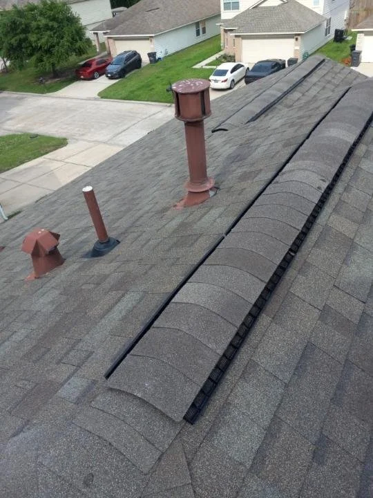 House roof with asphalt shingles, vents, and chimney