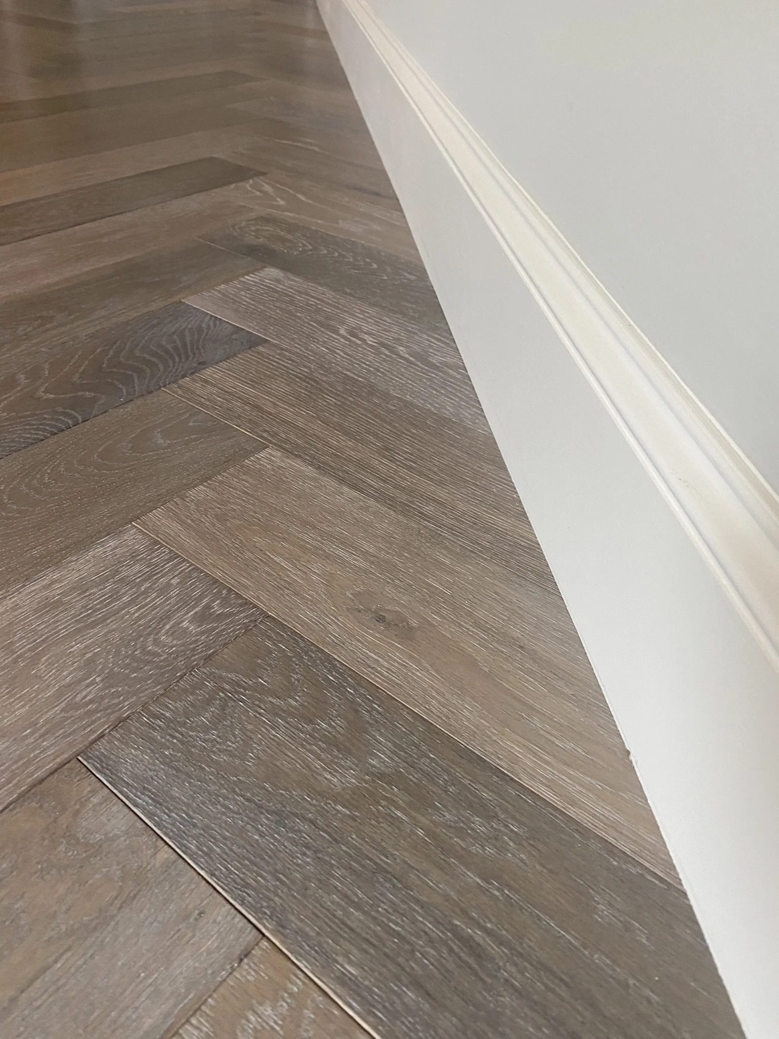 Herringbone hardwood floor pattern with baseboard
