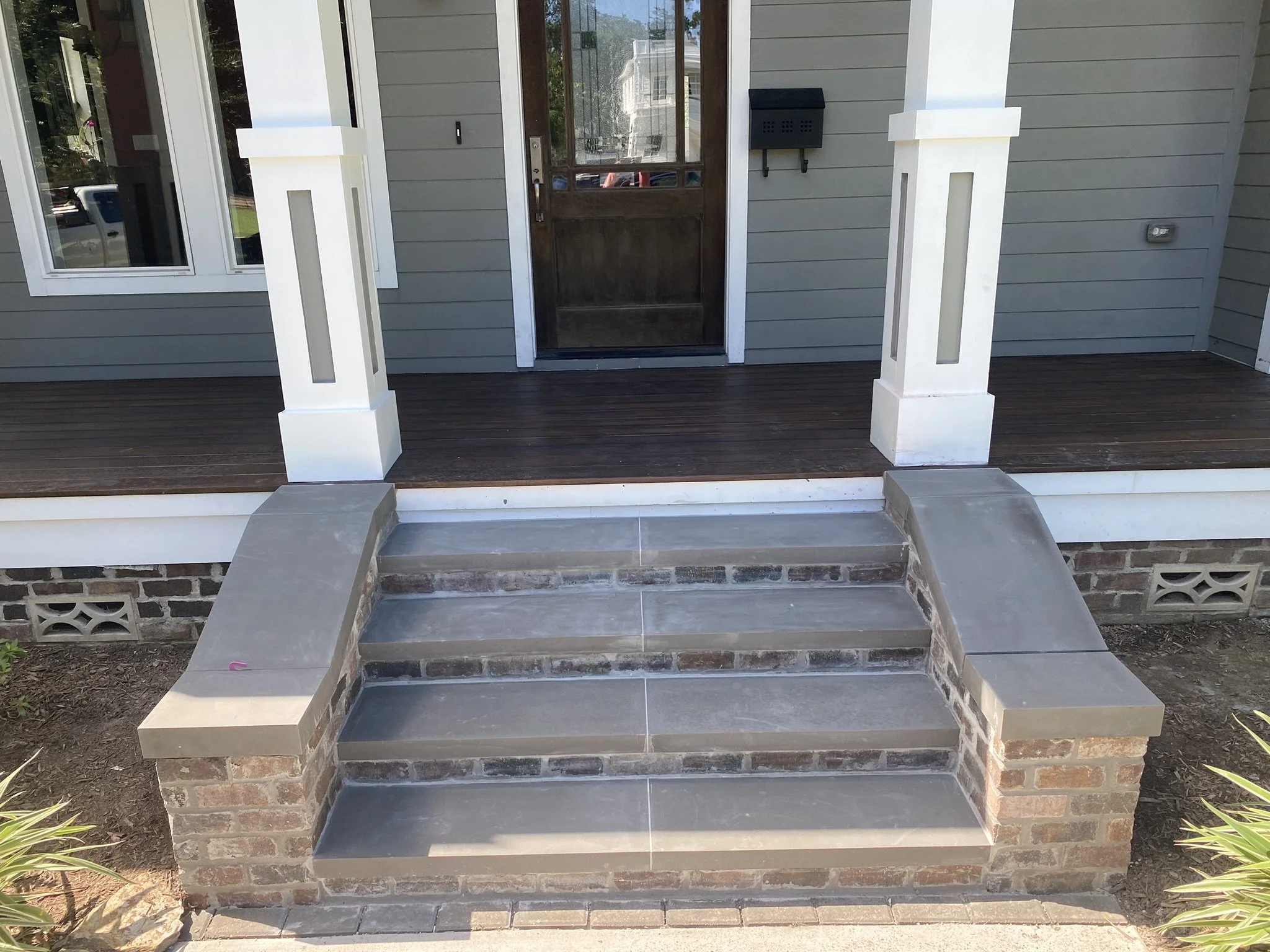 Front porch with gray steps and white columns