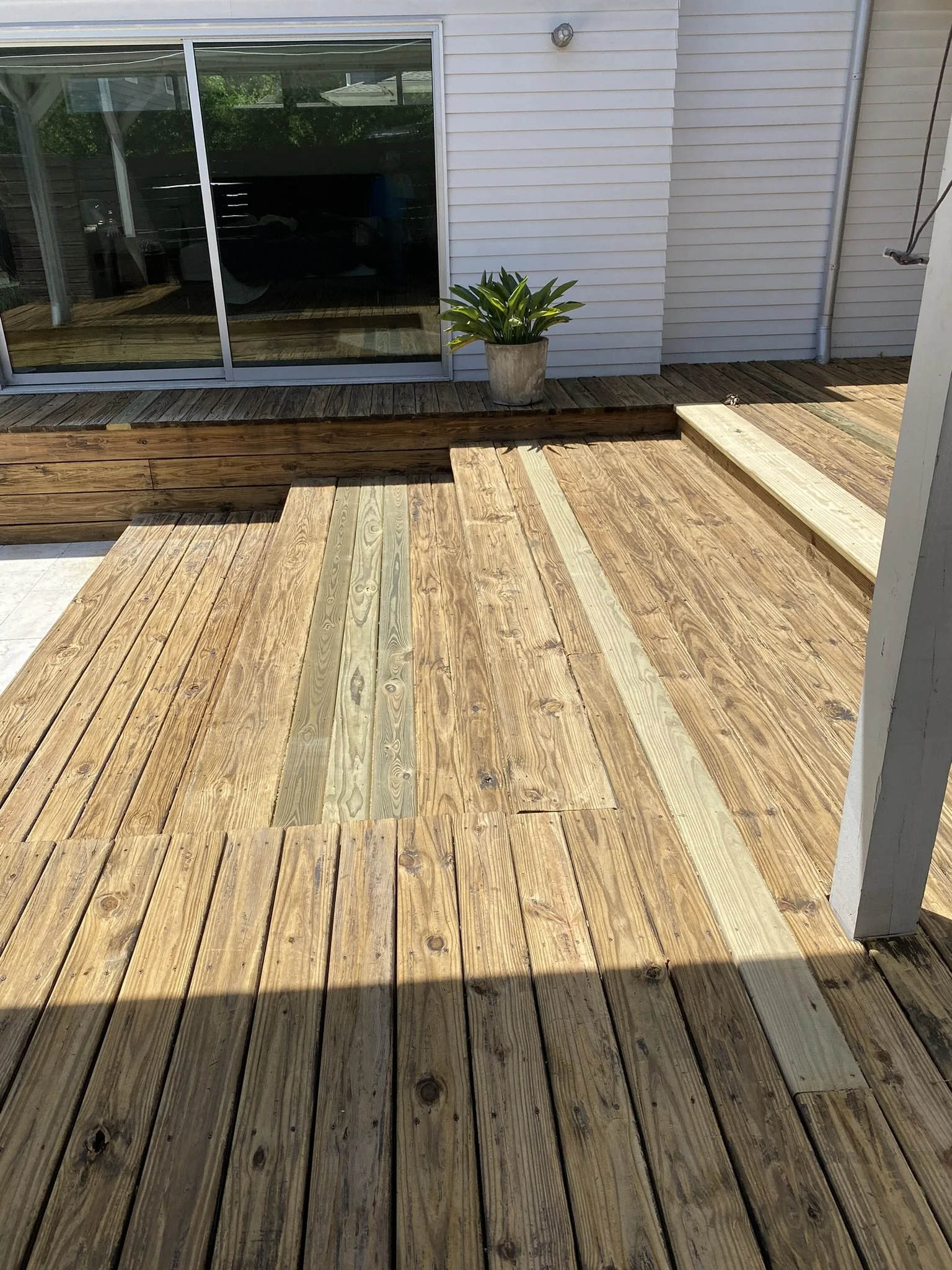 Wooden deck with steps and a potted plant