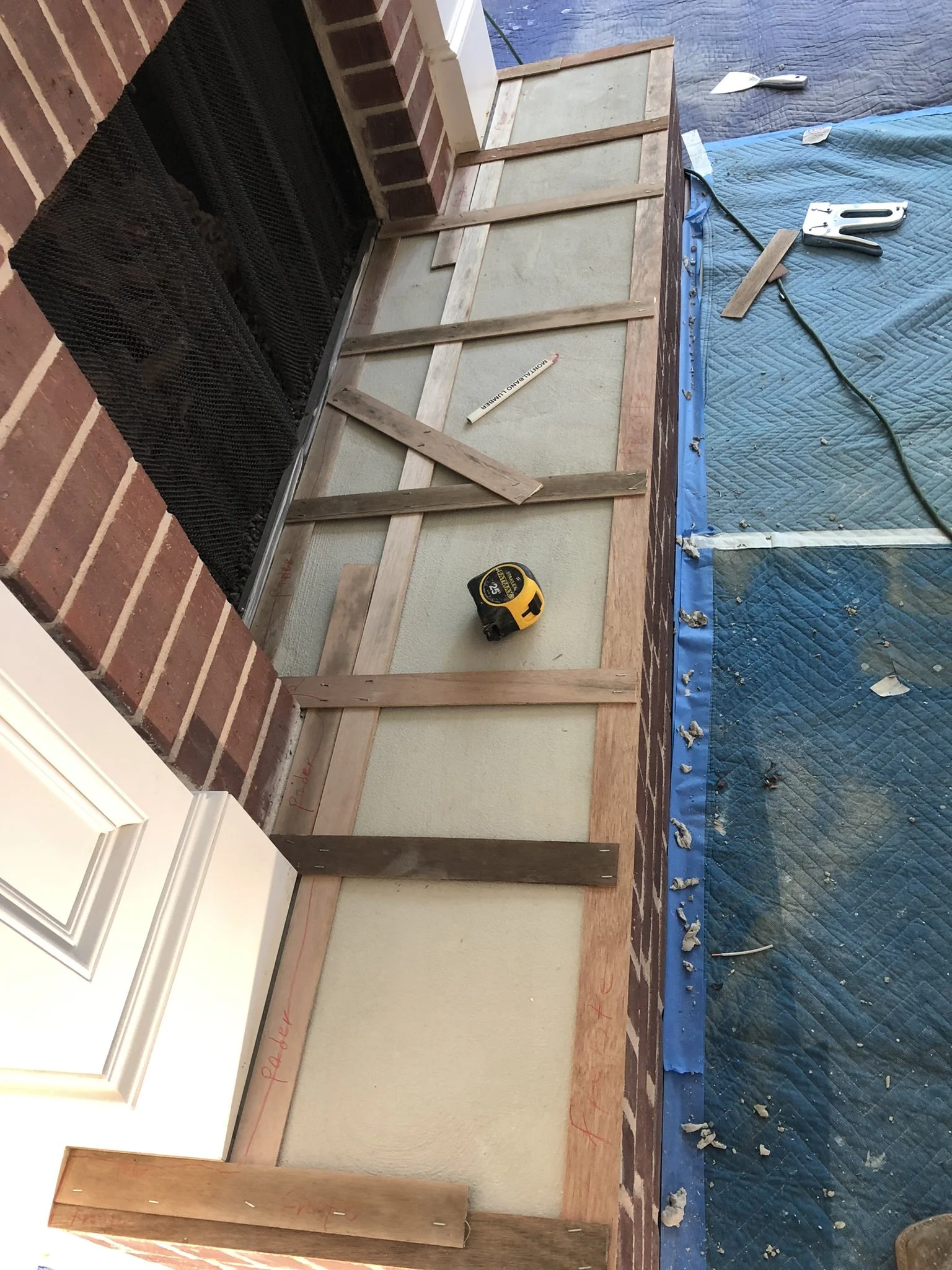 Fireplace construction with wooden framework, level tool, and stapler