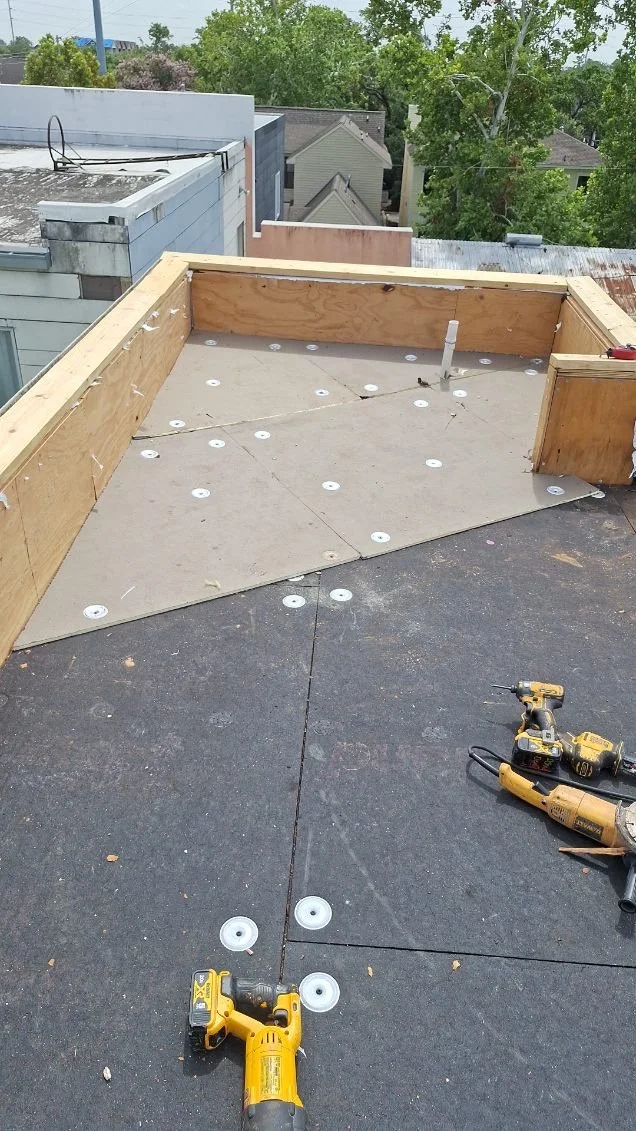 Rooftop under construction with tools and plywood boards