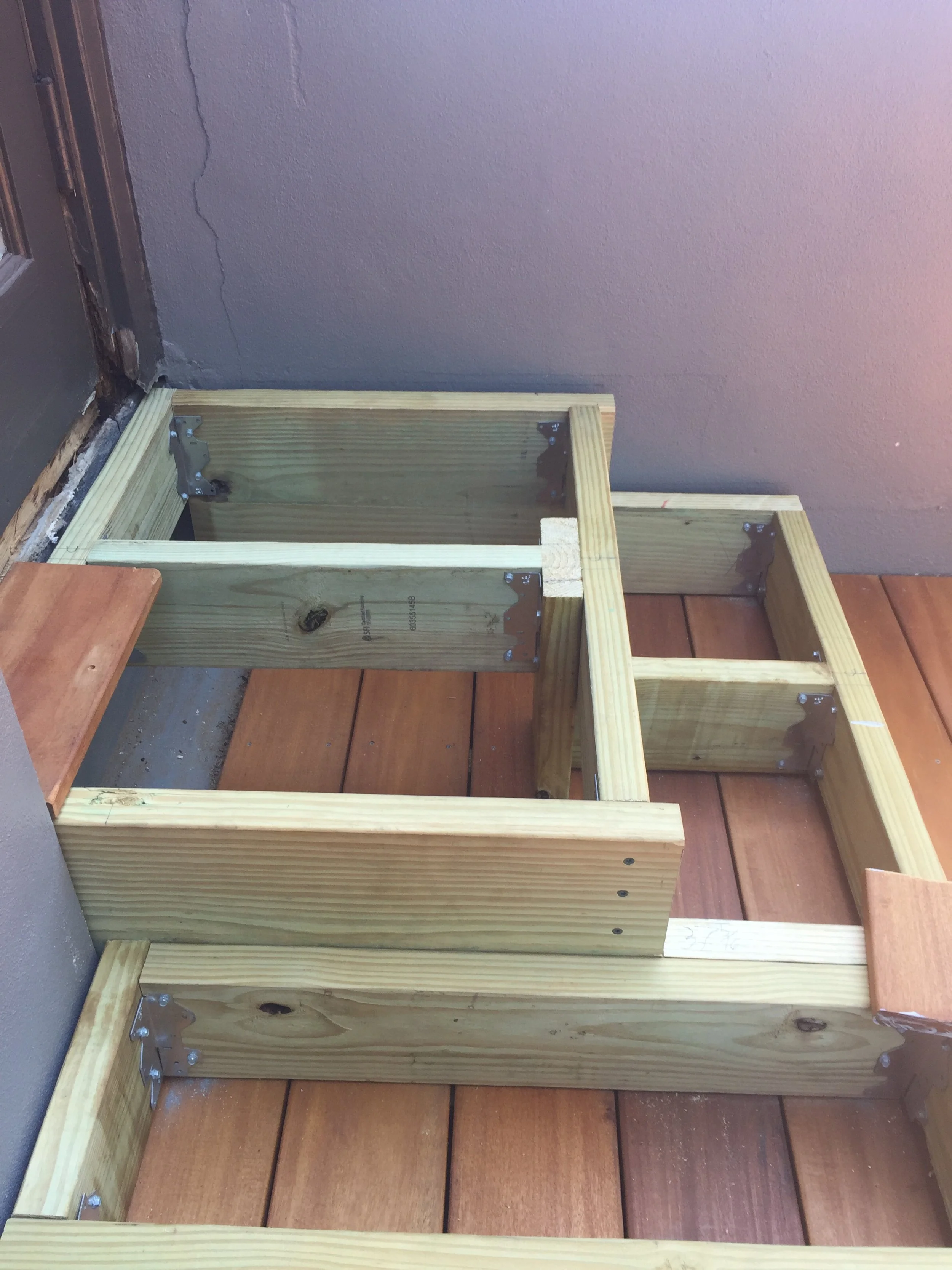 Wooden stair frame with visible metal brackets for step installation.