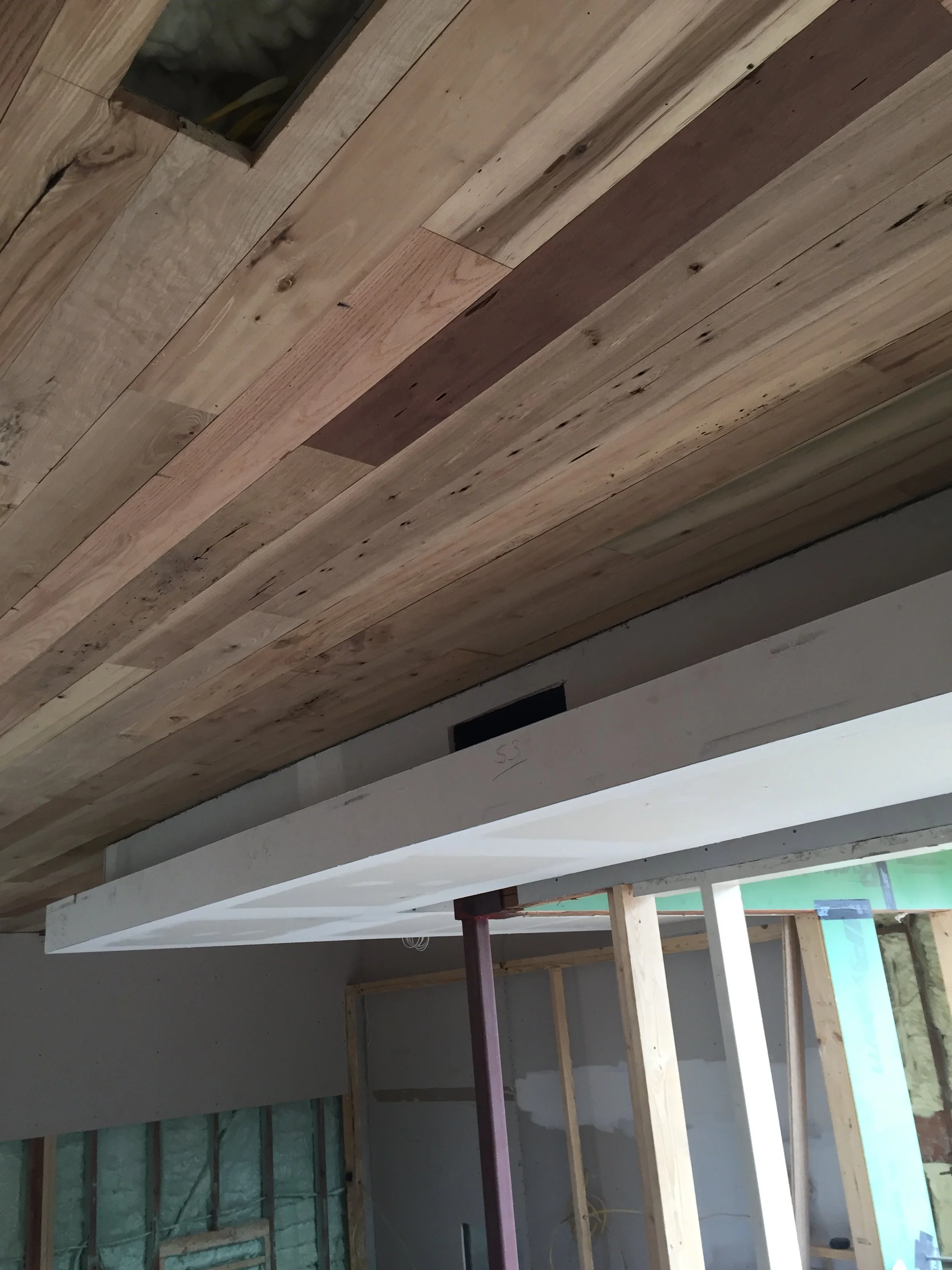 Construction site with unfinished wood ceiling and drywall partitions