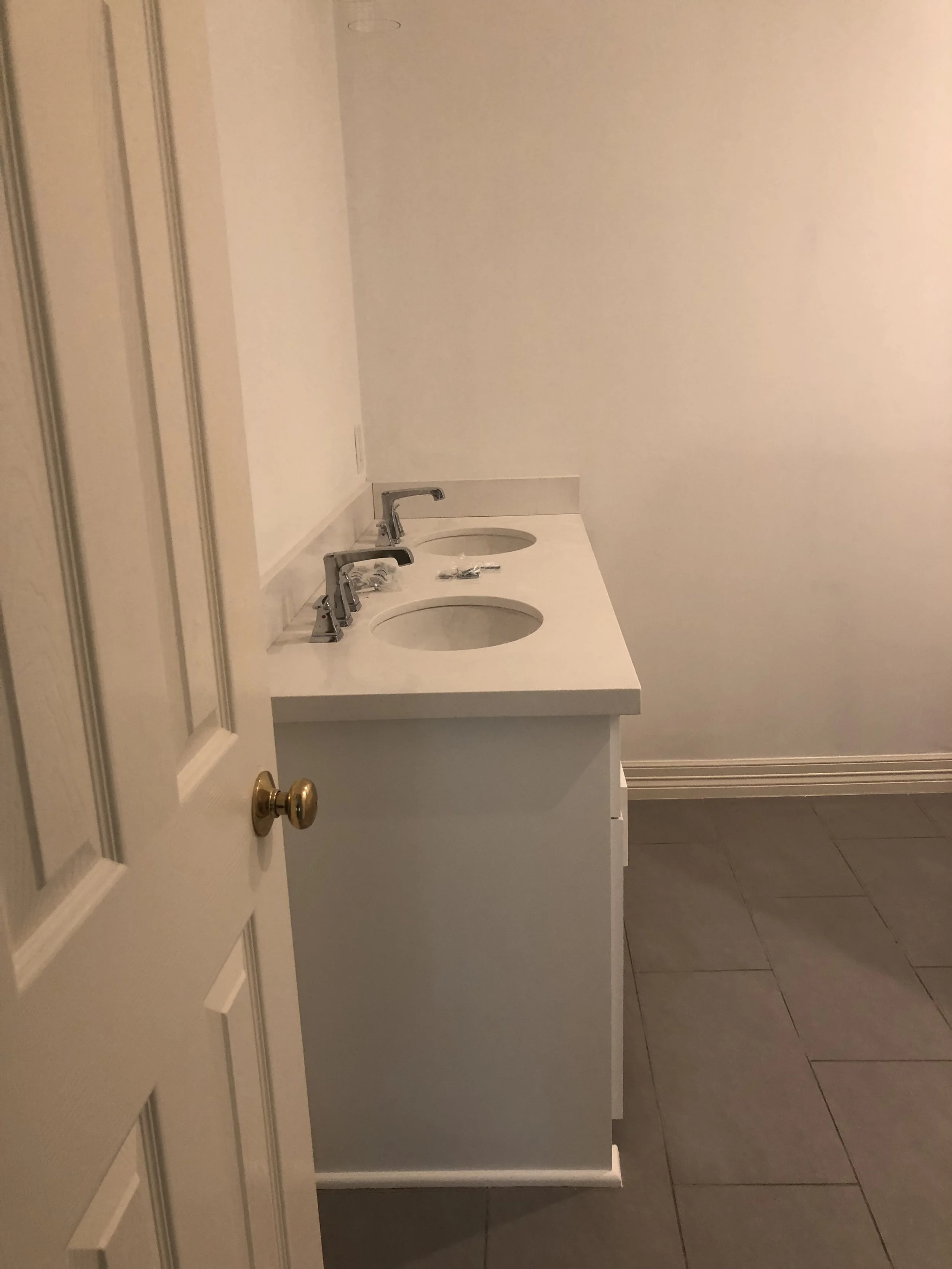 Bathroom with dual sinks and gray tile floor