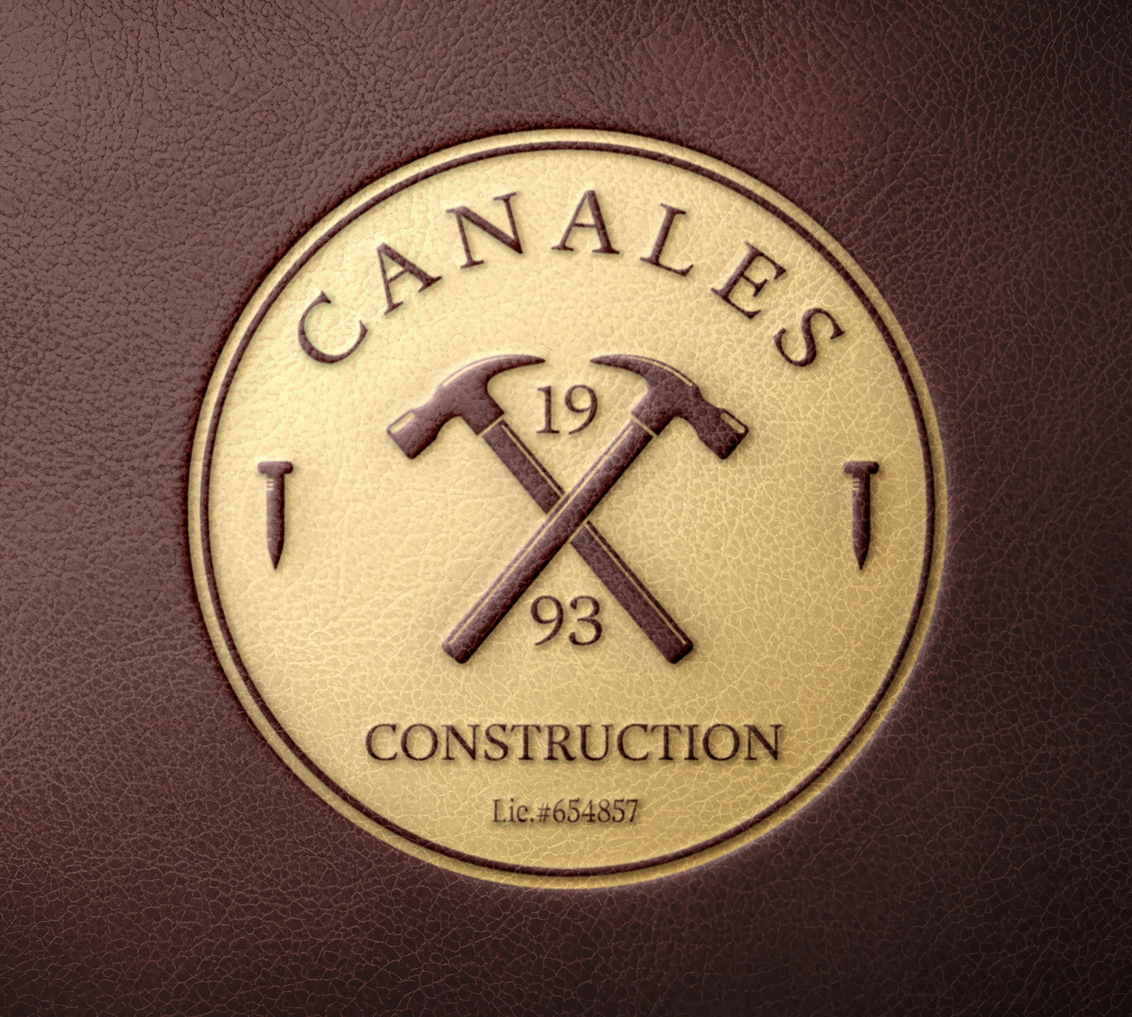 A circular emblem with the text 'CANALES 1993 CONSTRUCTION' and two crossed hammers in the center, on a textured brown background.