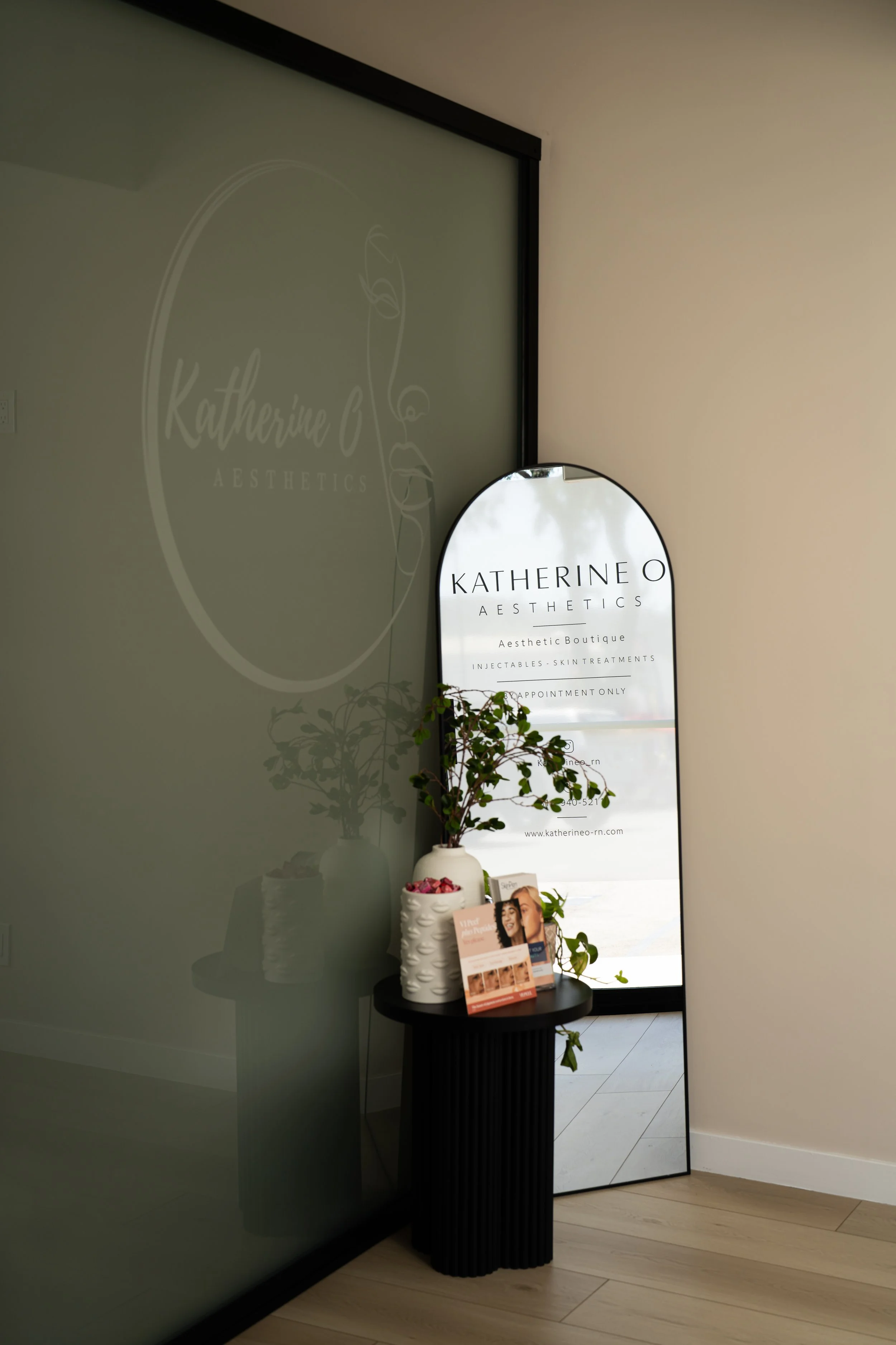 Entrance of Katherine O Aesthetics showing the frosted glass logo wall and arched signage for the aesthetic boutique.
