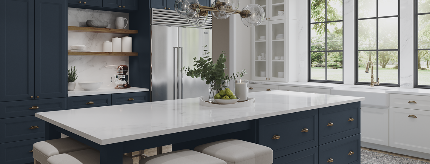 Modern kitchen with navy blue cabinets, white countertops, a large island with seating, open shelving, stainless steel refrigerator, and large windows with a view of greenery outside.