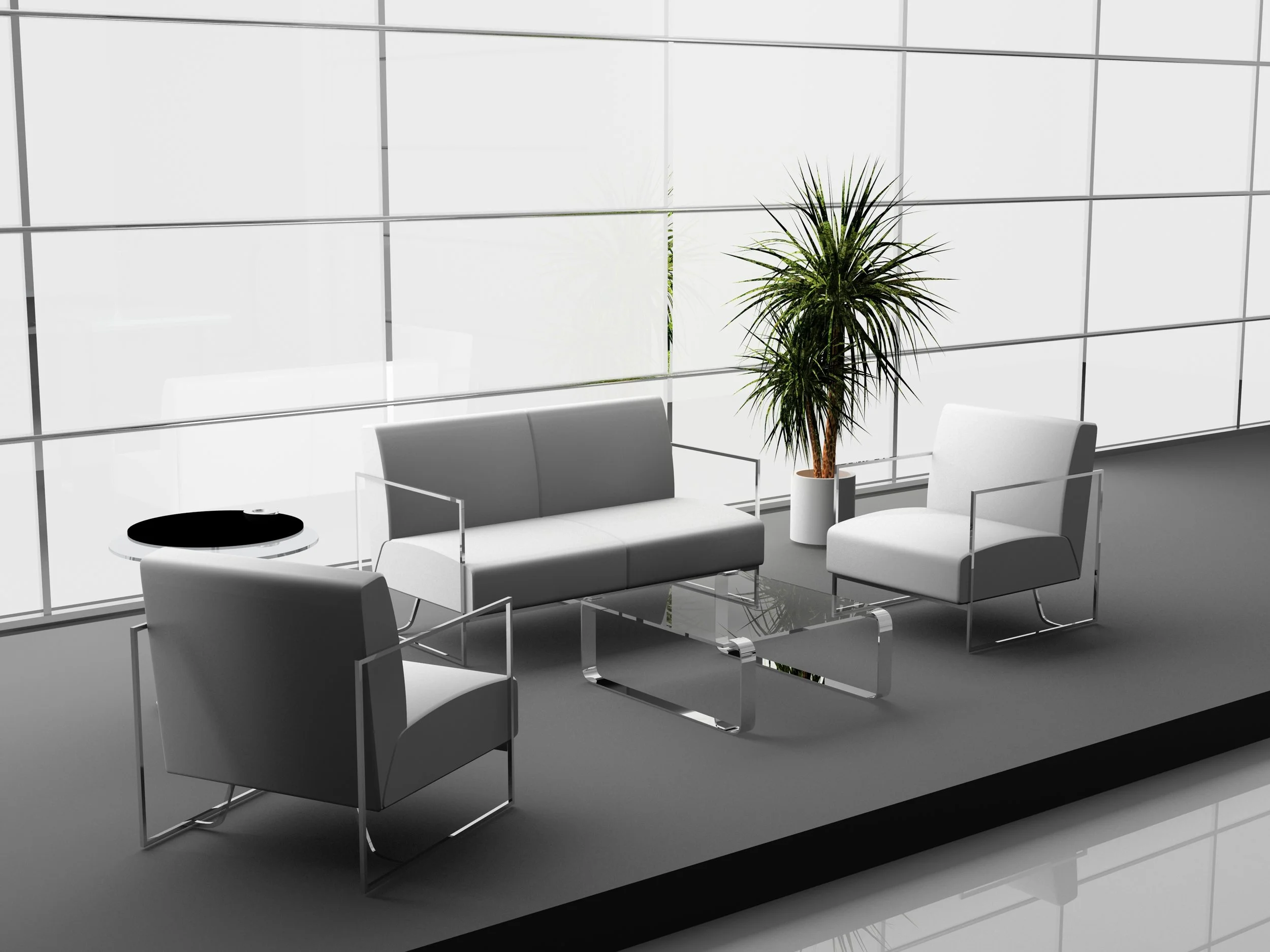 Modern office lounge with white sofa, two white armchairs, glass coffee table, small black side table with a black tray, and a tall green potted plant in front of large windows.