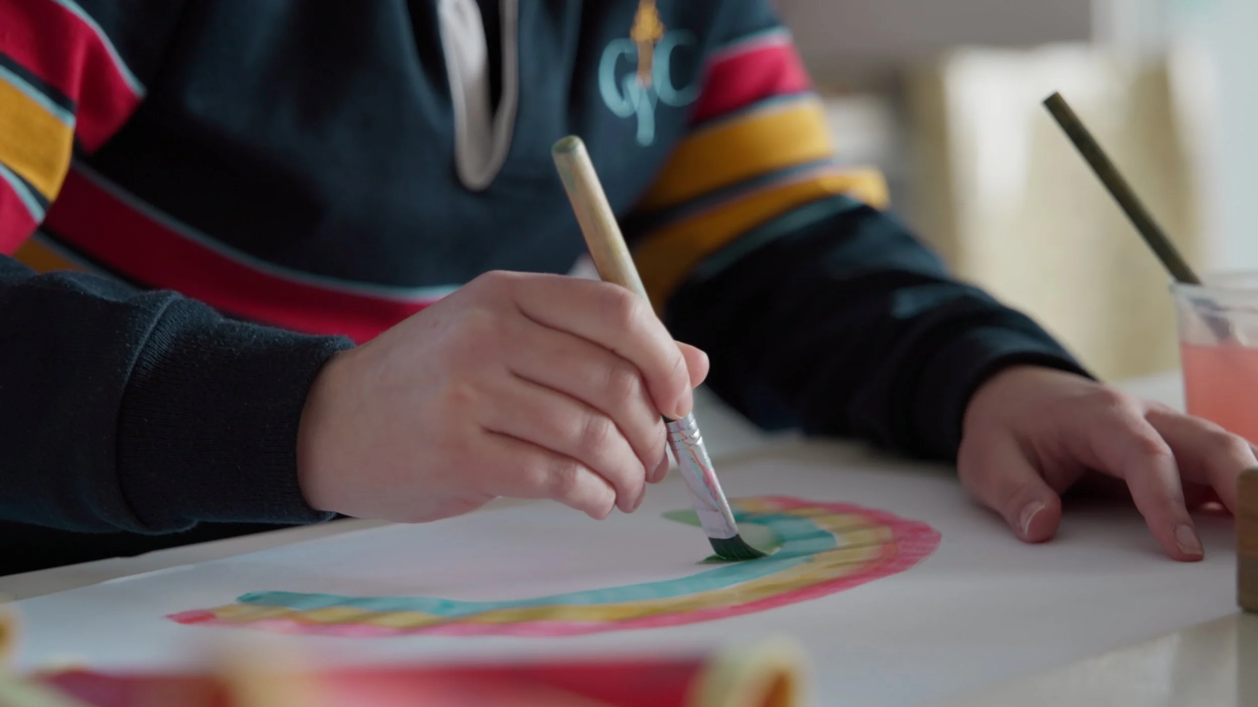 A person is painting a rainbow on a piece of paper with watercolor paints, using a fine brush. Shot in Hobart by Hamish Powell from Talon Media on a Canon C400 cinema camera.