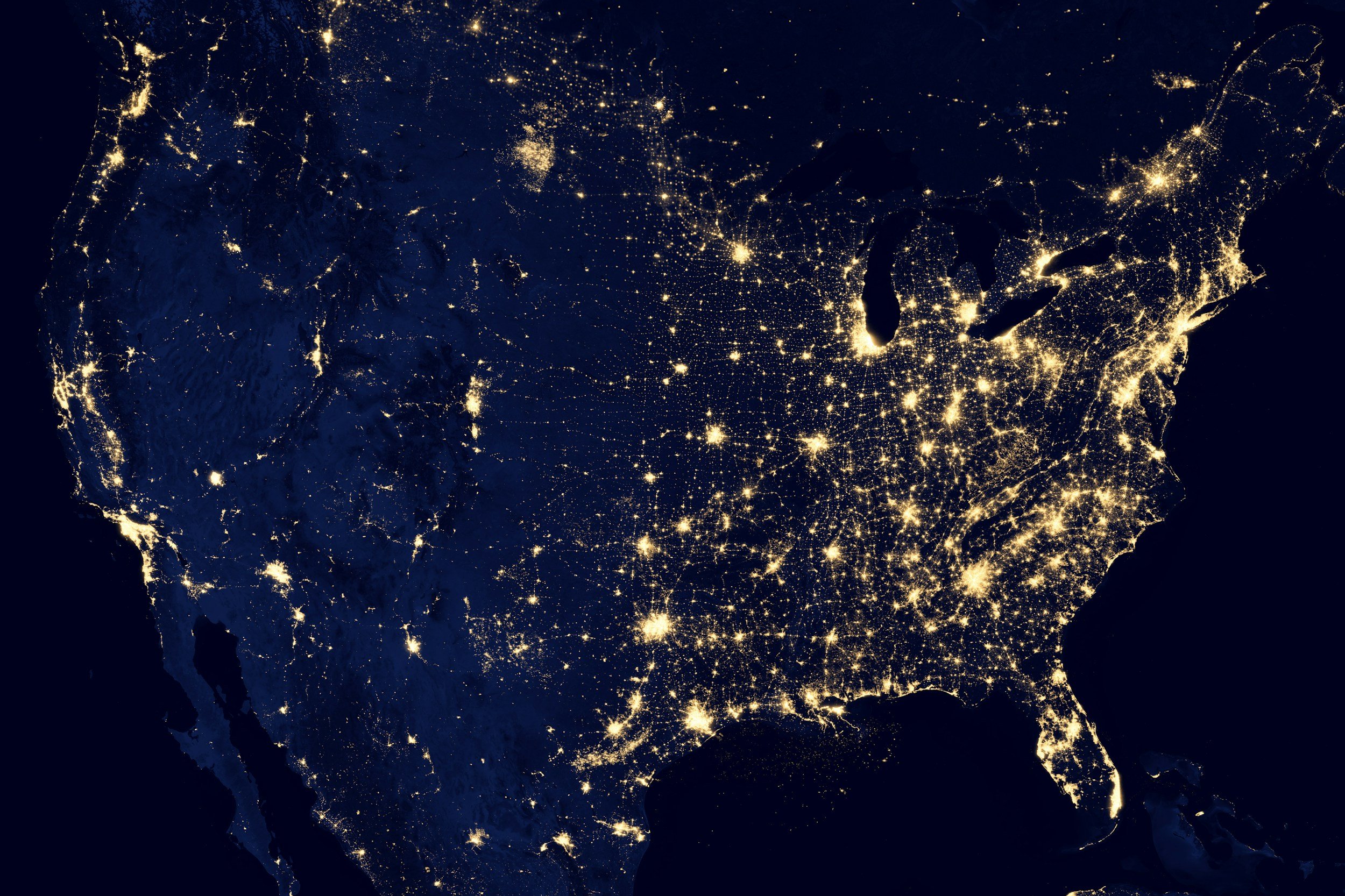 Nighttime satellite view of the United States showing city lights.