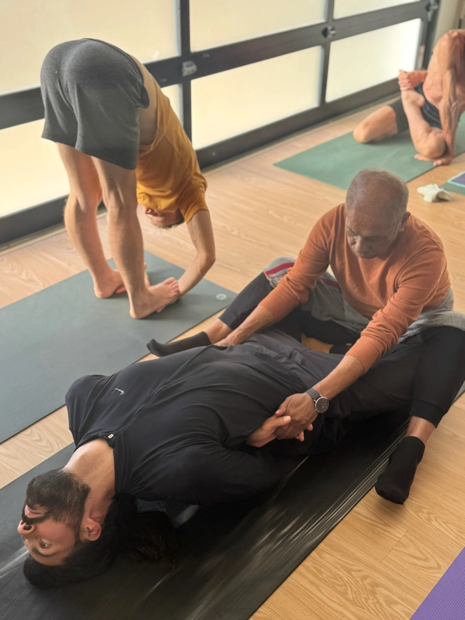 Manju P. Jois assisting Caio Amaral in Intermediate Series, Supta Vajrasana, California