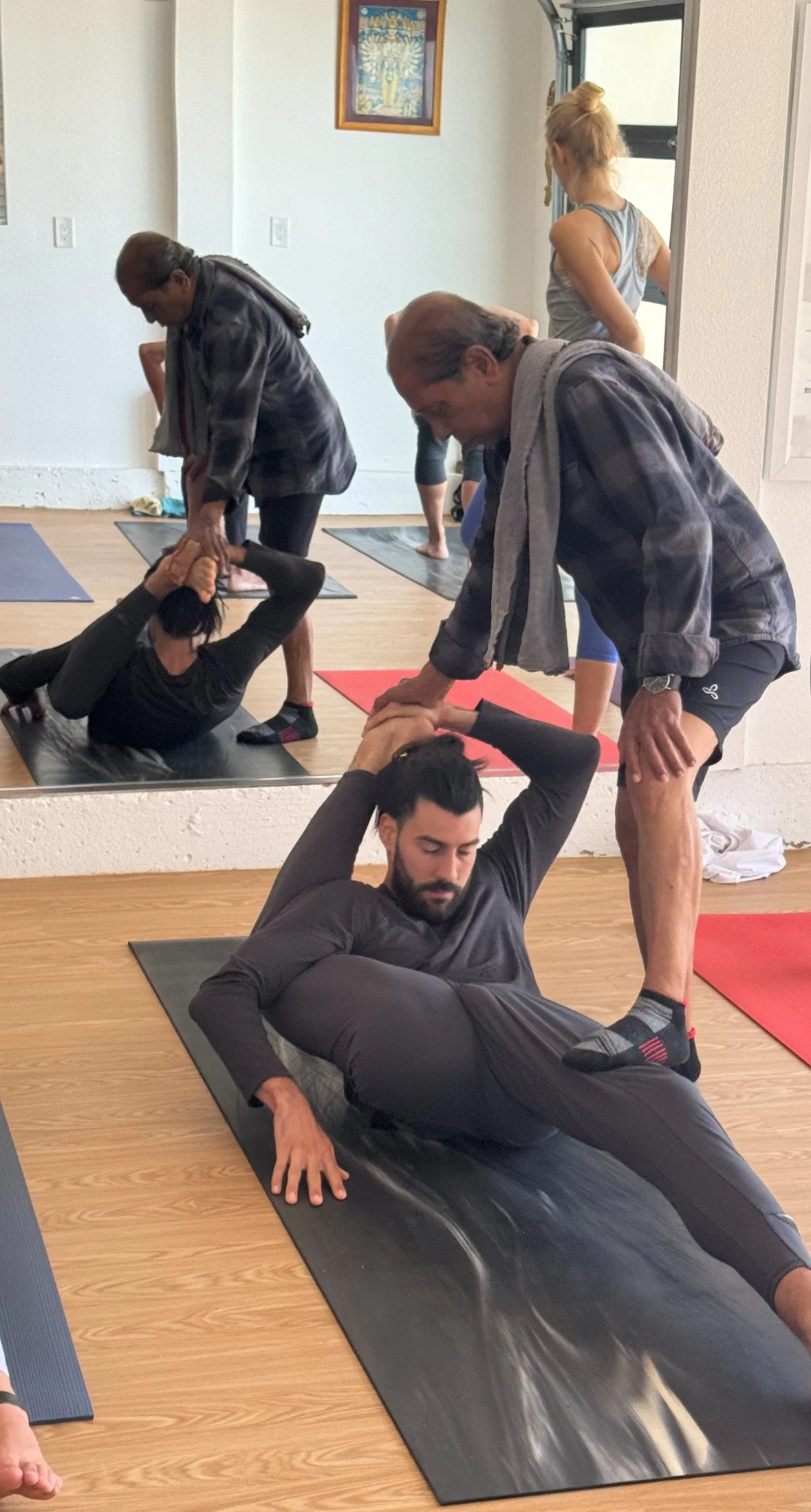 Manju P. Jois assisting Caio Amaral,  Kaśypāsana of Advanced Series Ashtanga Yoga
