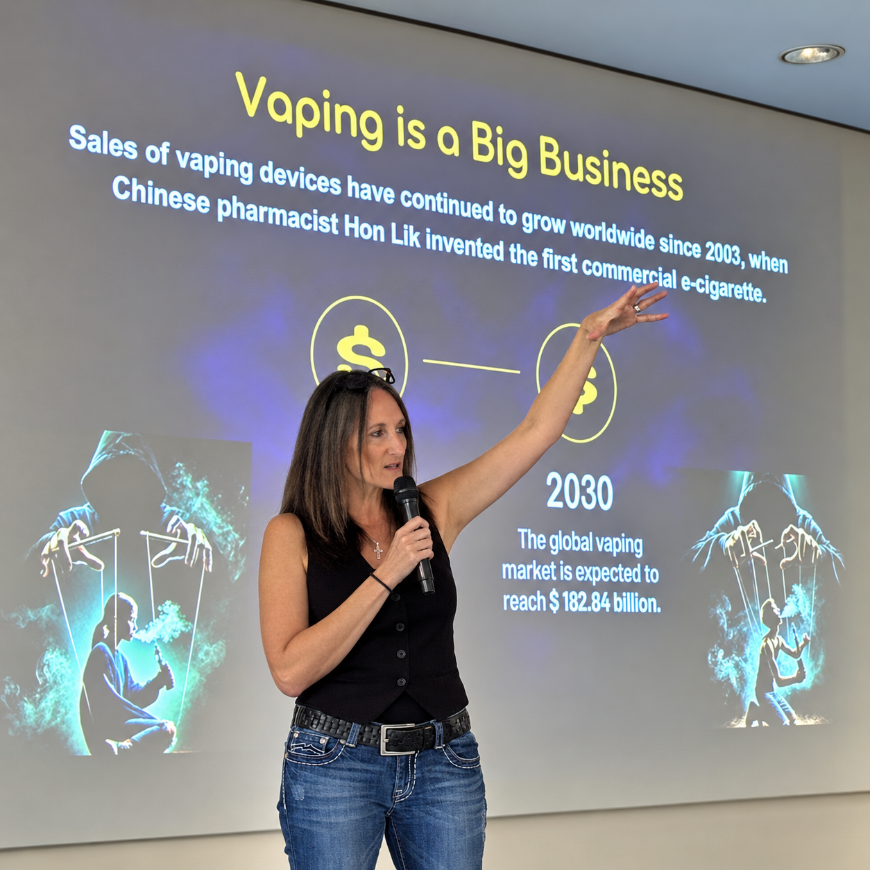 Azelene Williams giving a presentation about vaping on a projection screen, with a microphone in her hand and her other hand raised, discussing the growth of the vaping industry and its market forecast.