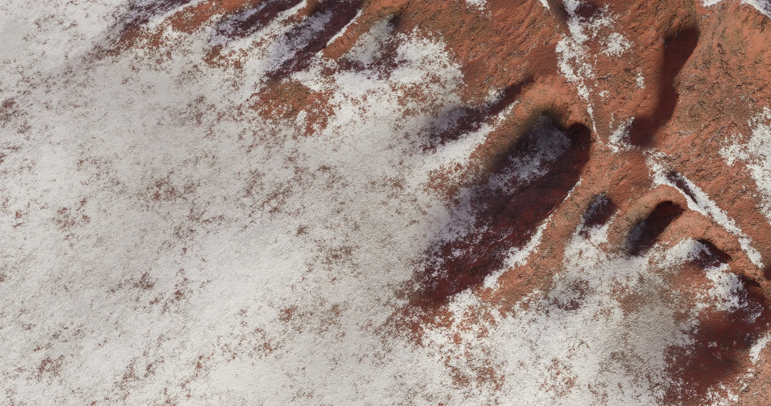 Close-up view of a rock surface with reddish-brown color, partially covered with snow, highlighting the texture and crevices in the rock.