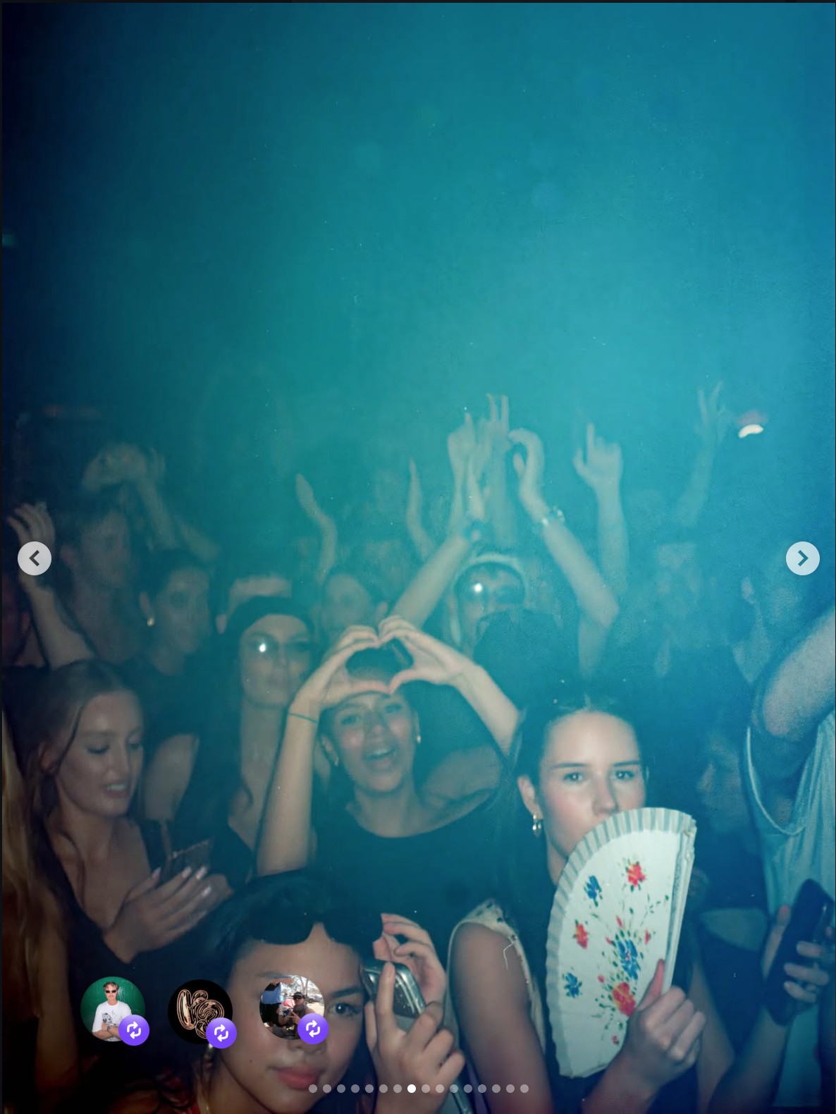 Group of young people at a party or nightclub, some holding smartphones, one woman making a heart shape with her hands, others raising their hands, and a woman holding a floral fan. The scene is dark with a blue background.