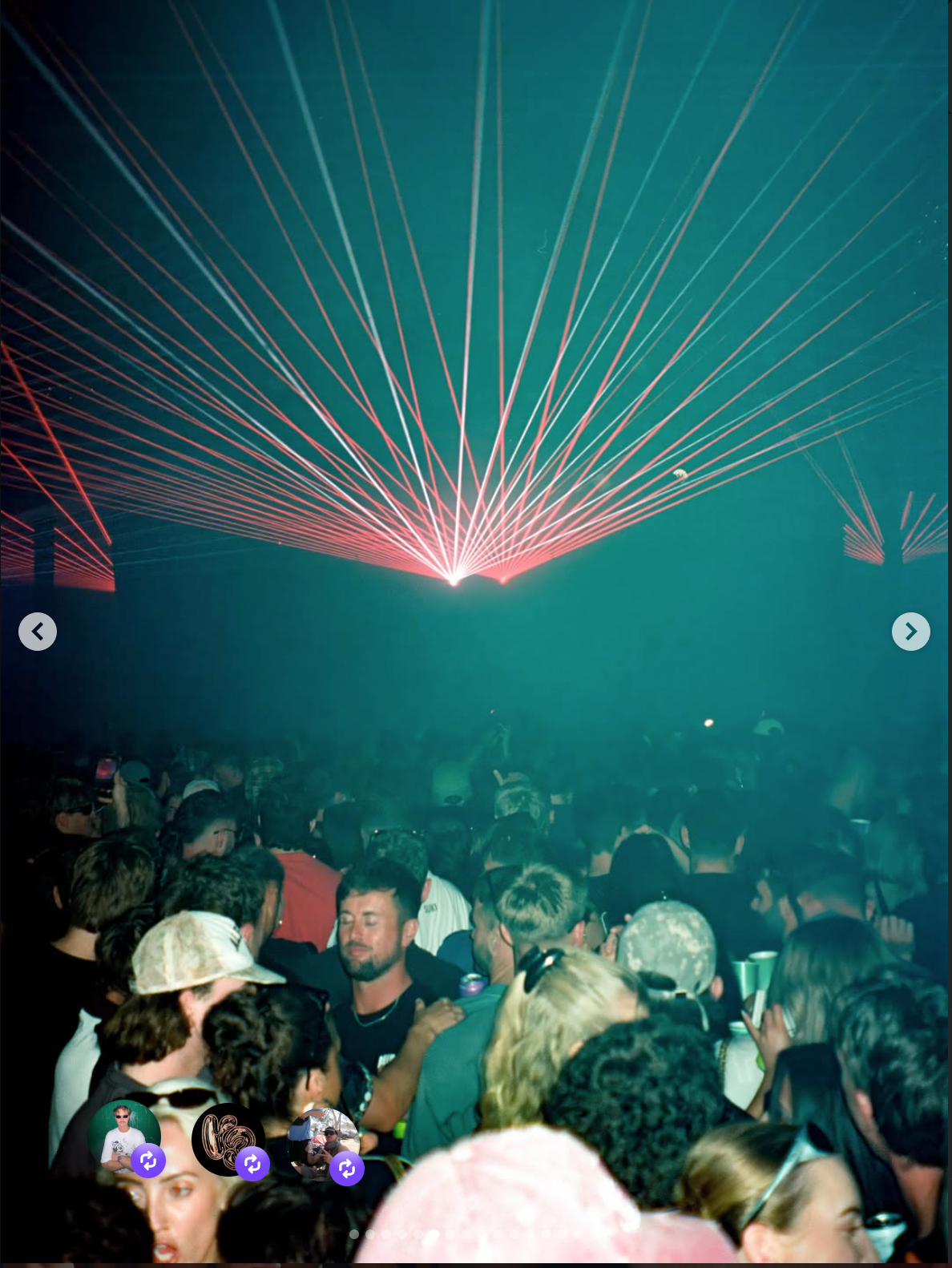 Crowd of people watching a laser light show with red and blue beams in a dark setting.