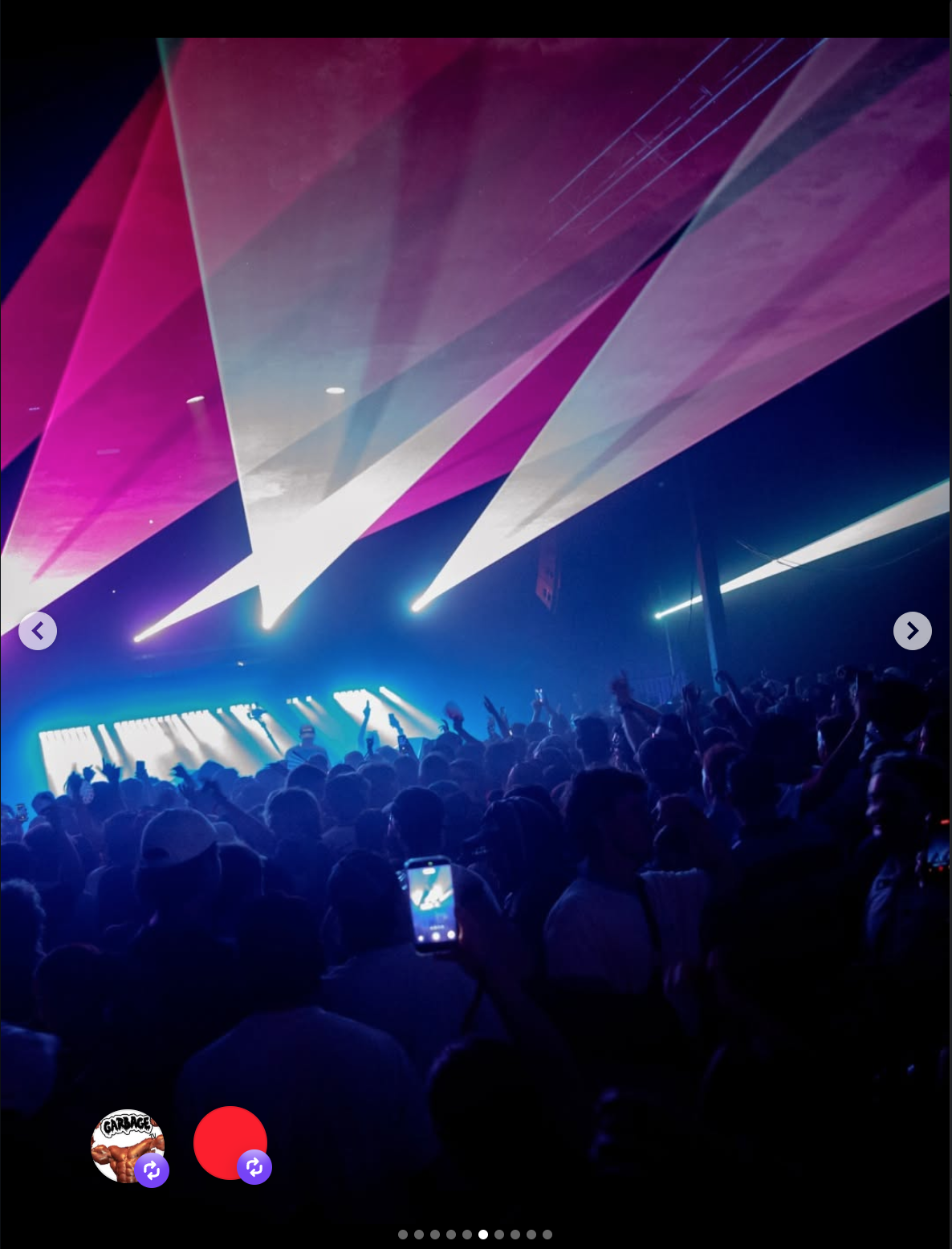 Crowd at a concert with stage and colorful laser lights overhead.