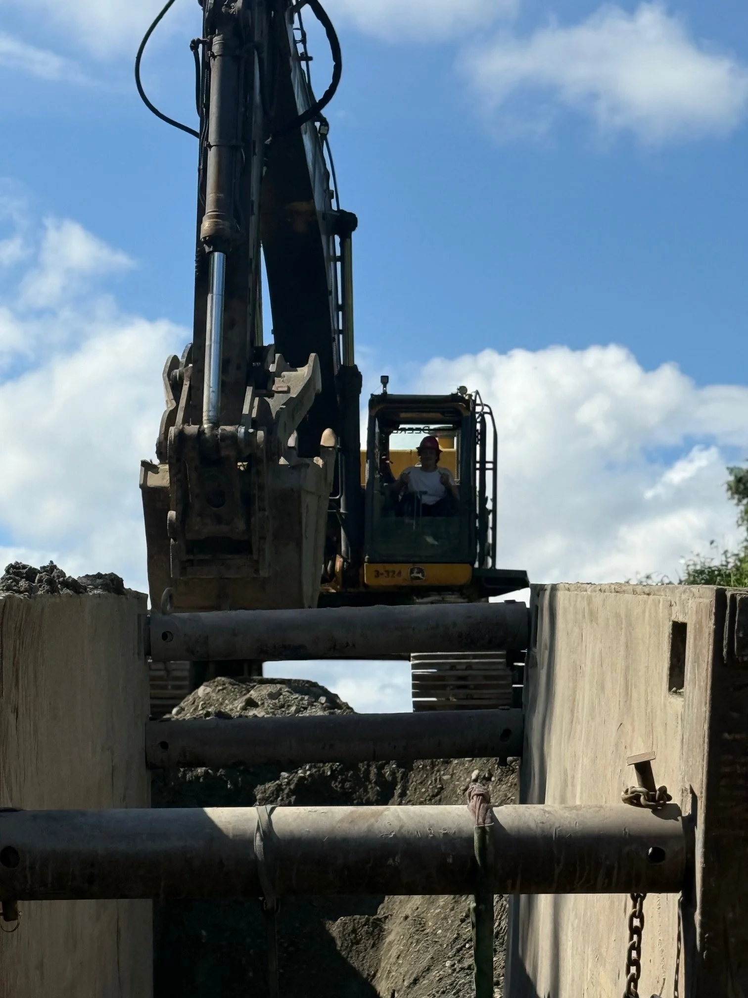 A construction worker operating a large excavator on a construction site during daytime.