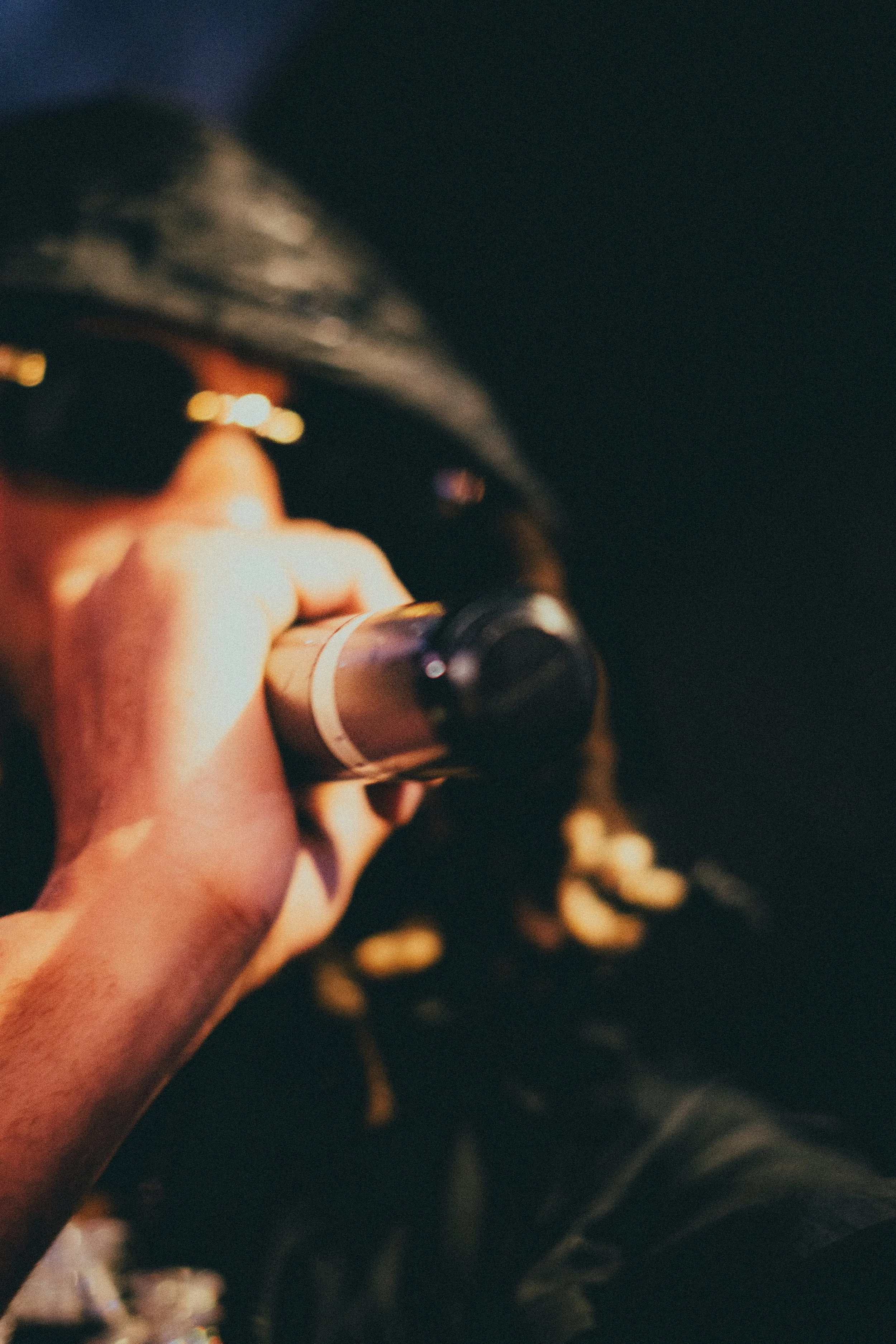Une personne portant des lunettes de soleil utilise une loupe ou un télescope, dans un environnement sombre avec peu d'éclairage.