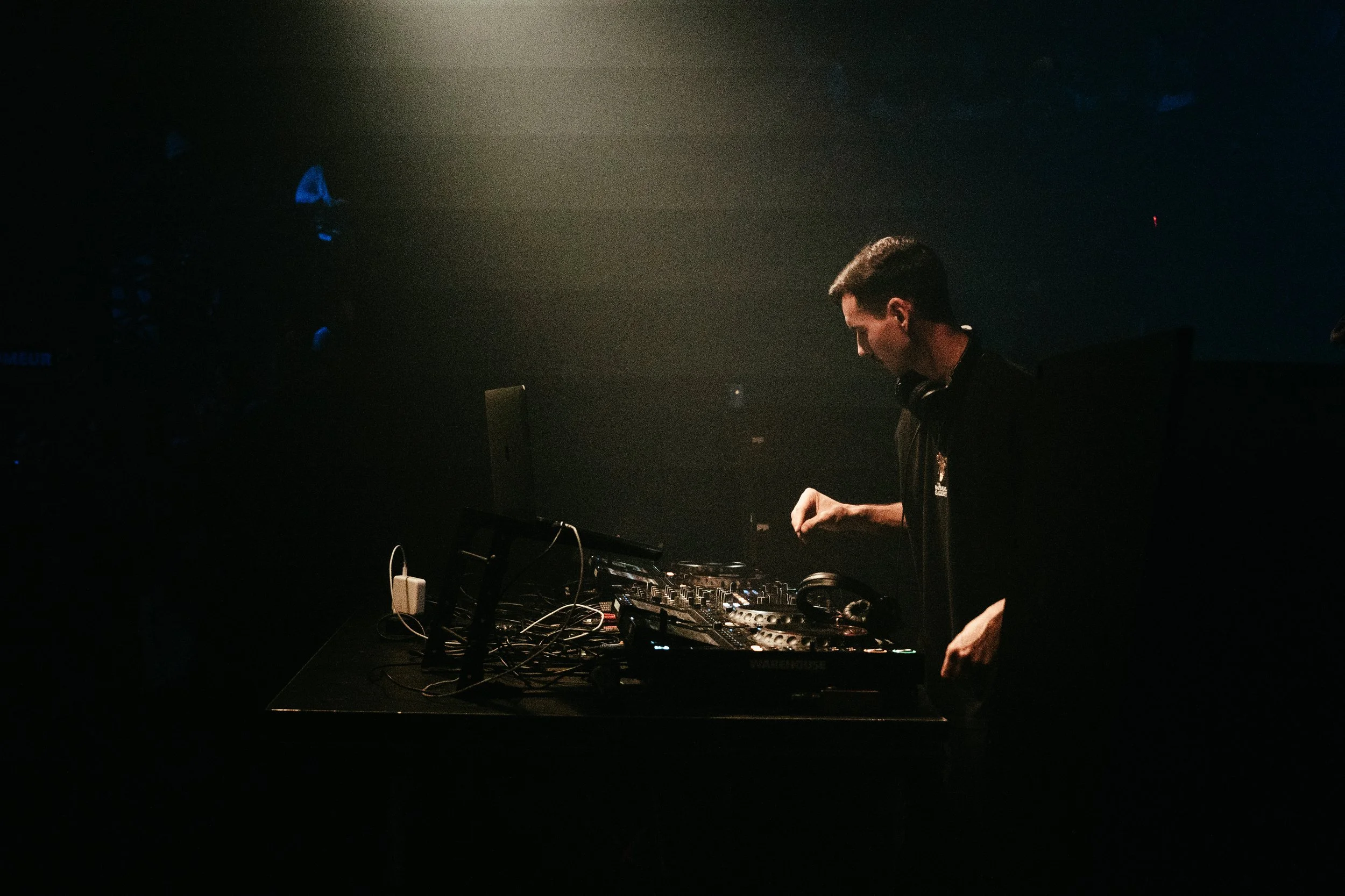 DJ en train de mixer dans une pièce sombre