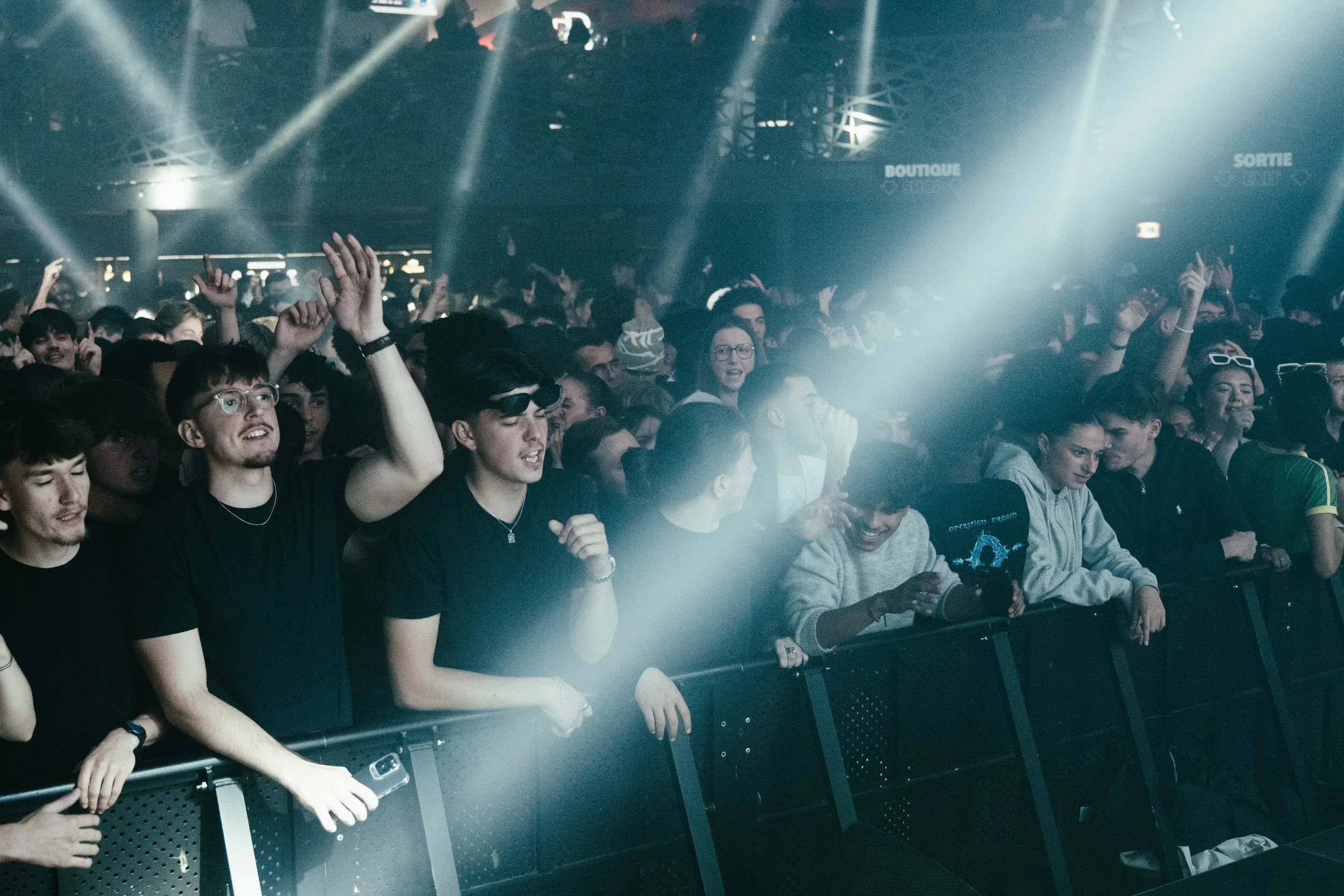 Public lors d'un concert de musique électronique avec des lumières et une foule enthousiaste