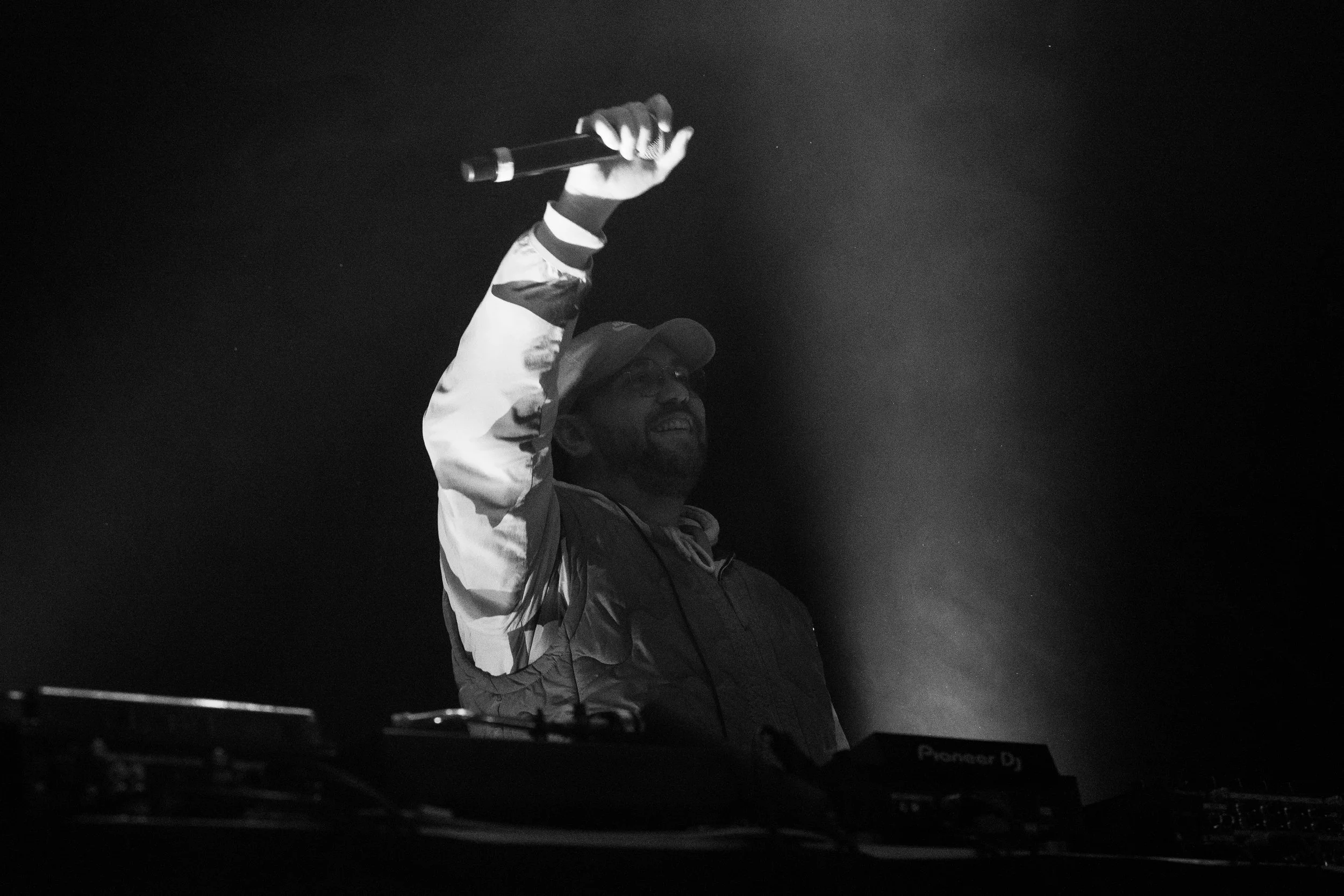 DJ jouant de la musique dans un club sombre, utilisant un casque et une table de mixage.