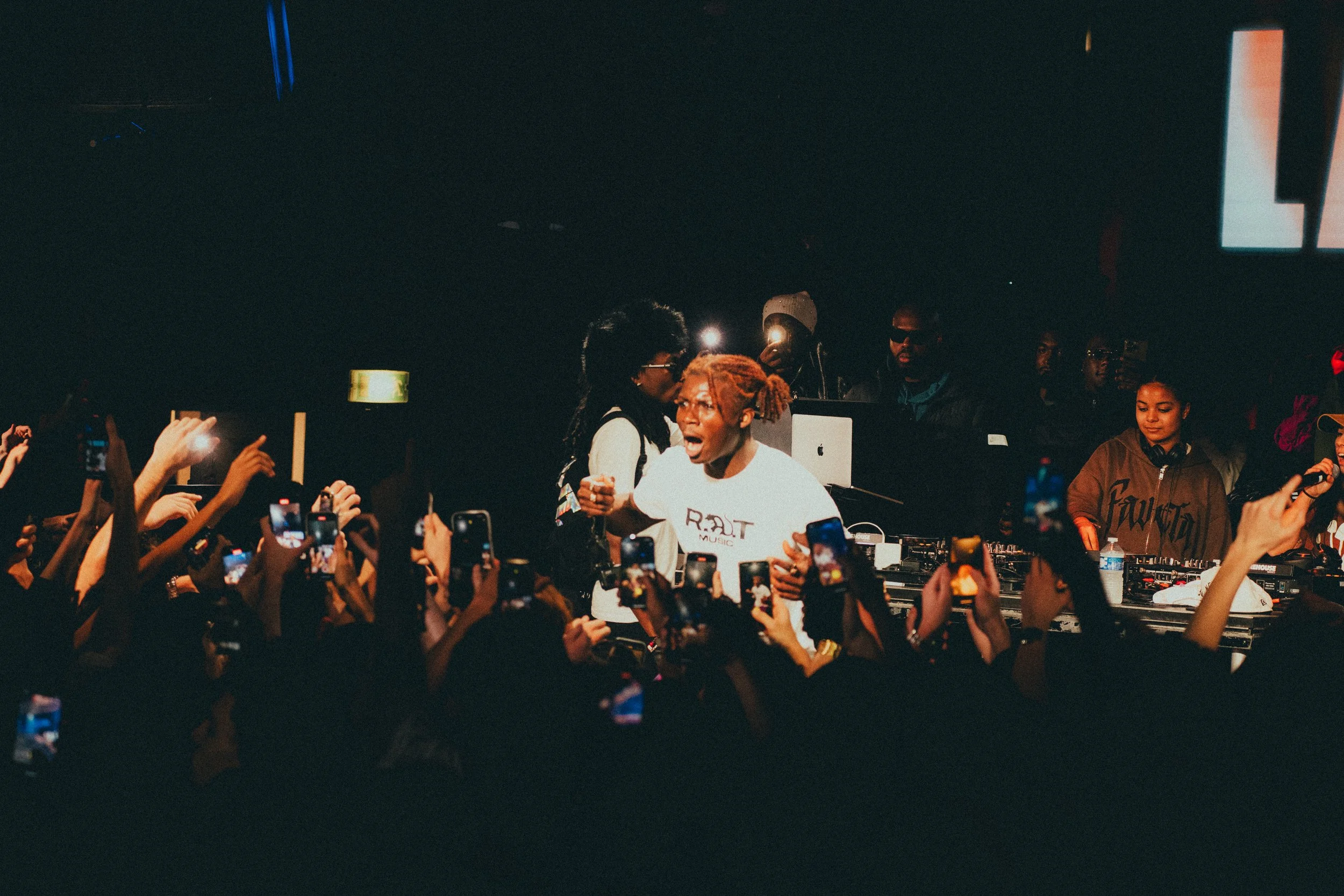 Un DJ sur scène avec un public nombreux en festoyant lors d'un concert ou d'une fête