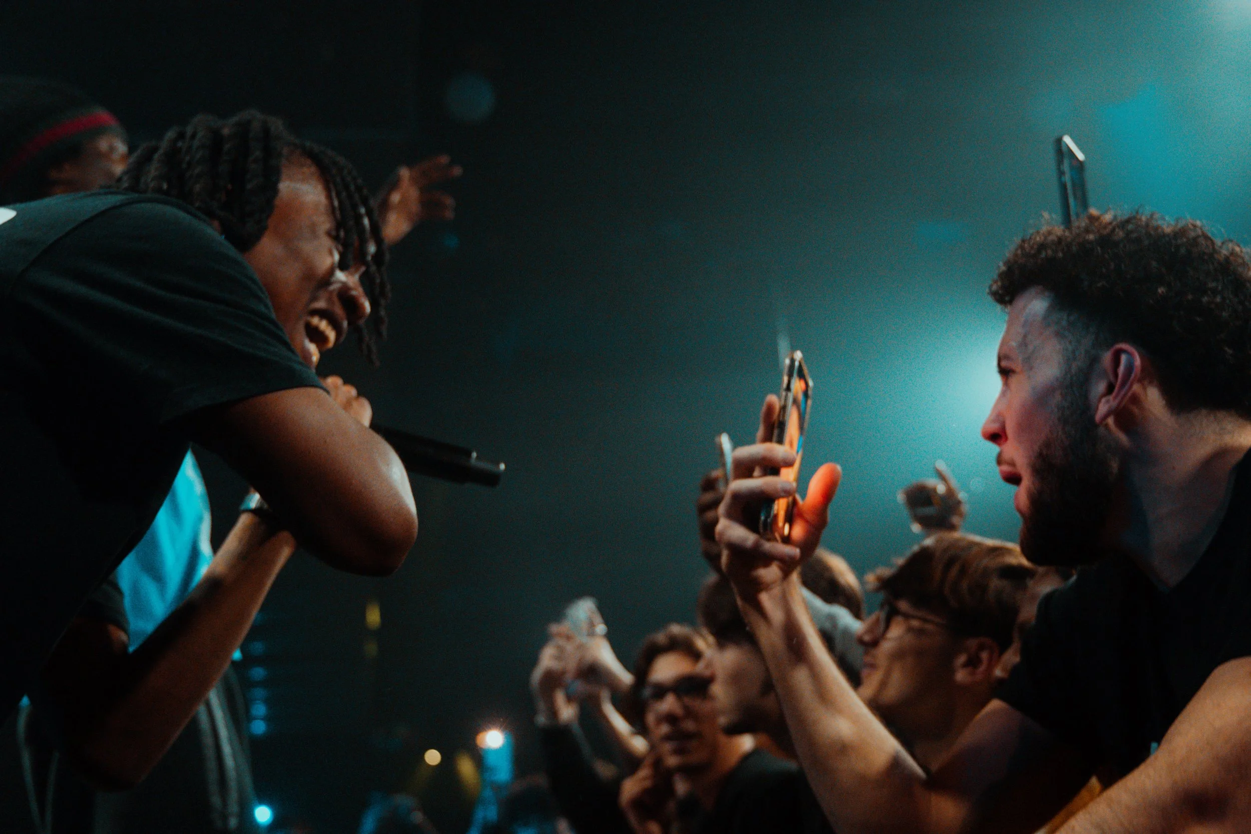 Un groupe de jeunes en train de rire et prendre des selfies lors d'un concert ou d'un événement musical.