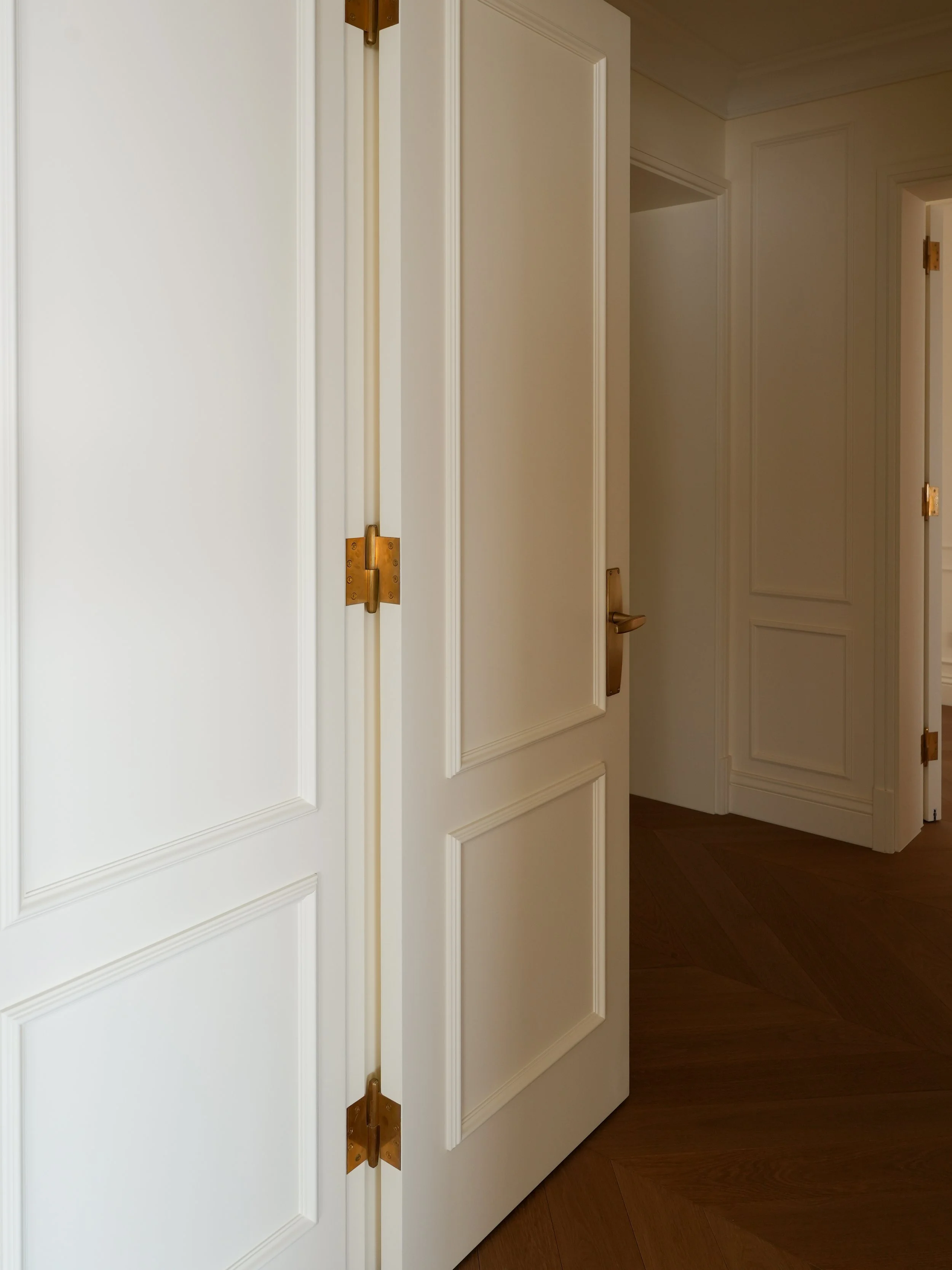Von Morris light-patina brass lever and mortise lock hardware installed on a residential interior door
