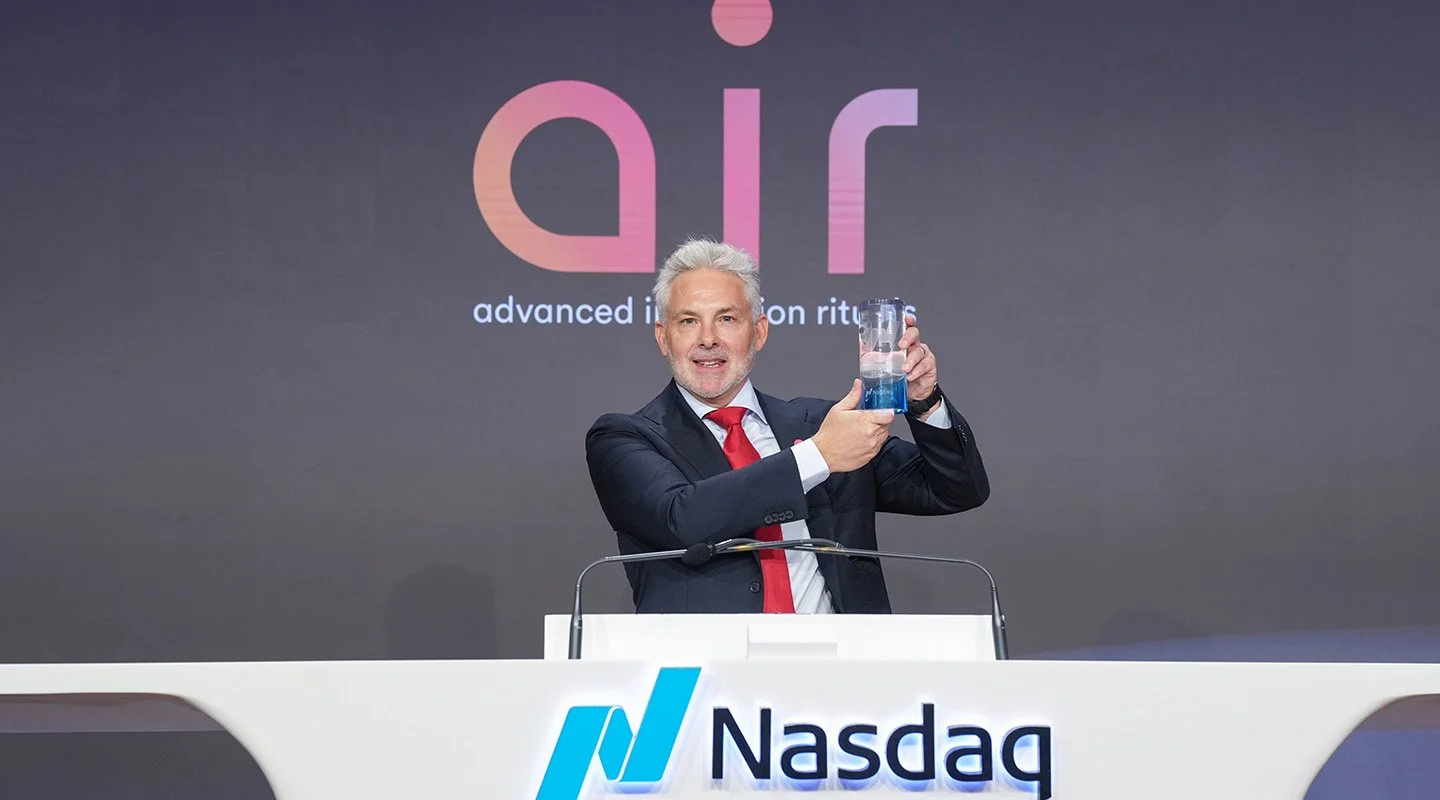 AIR CEO, Stuart holds a commemorative Nasdaq crystal award during the company’s listing ceremony.