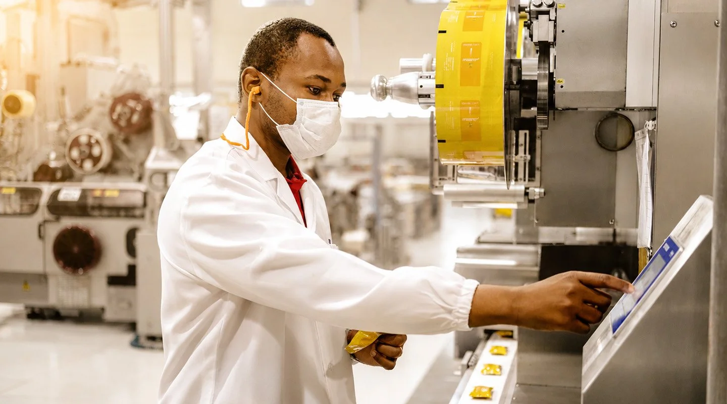 Al Fakher quality team member inspecting packaging on an automated production line.