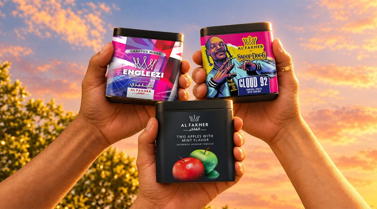 Three Al Fakher summer shisha tobacco flavors, Engleezi, Cloud 92 and Two Apples with Mint, held up against a colorful sunset sky.
